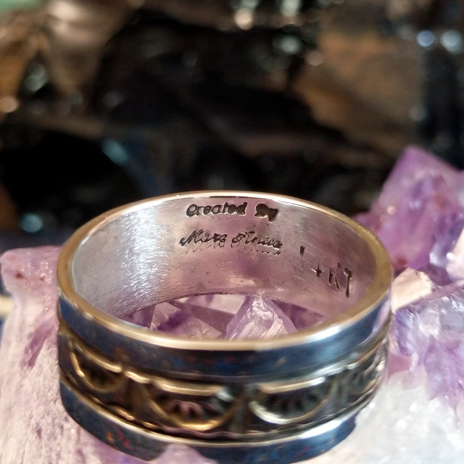 Artist's signature is etched into the inside of the ring.
