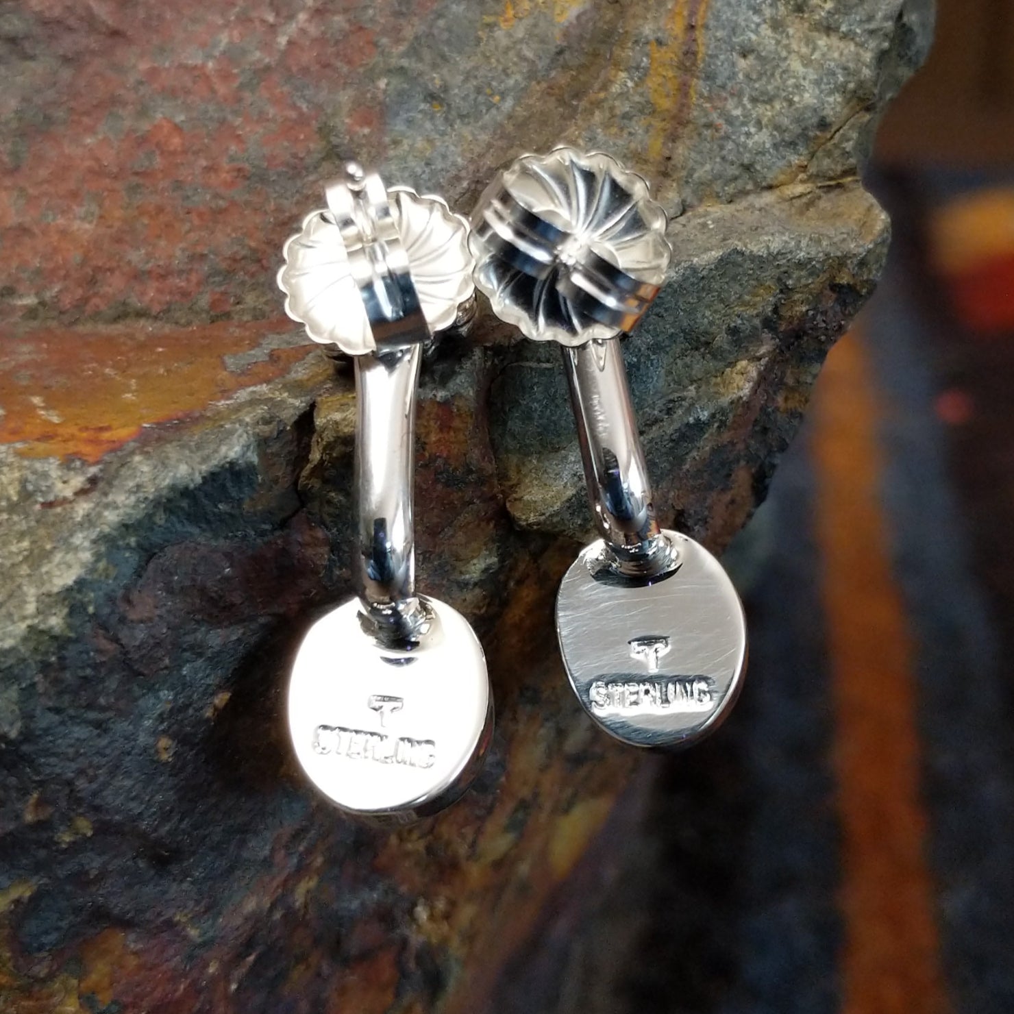 Stamped view of Golden Hills turquoise adjustable earrings showing the sterling silver backing with a signature mark by Navajo artist Terry Wood.
