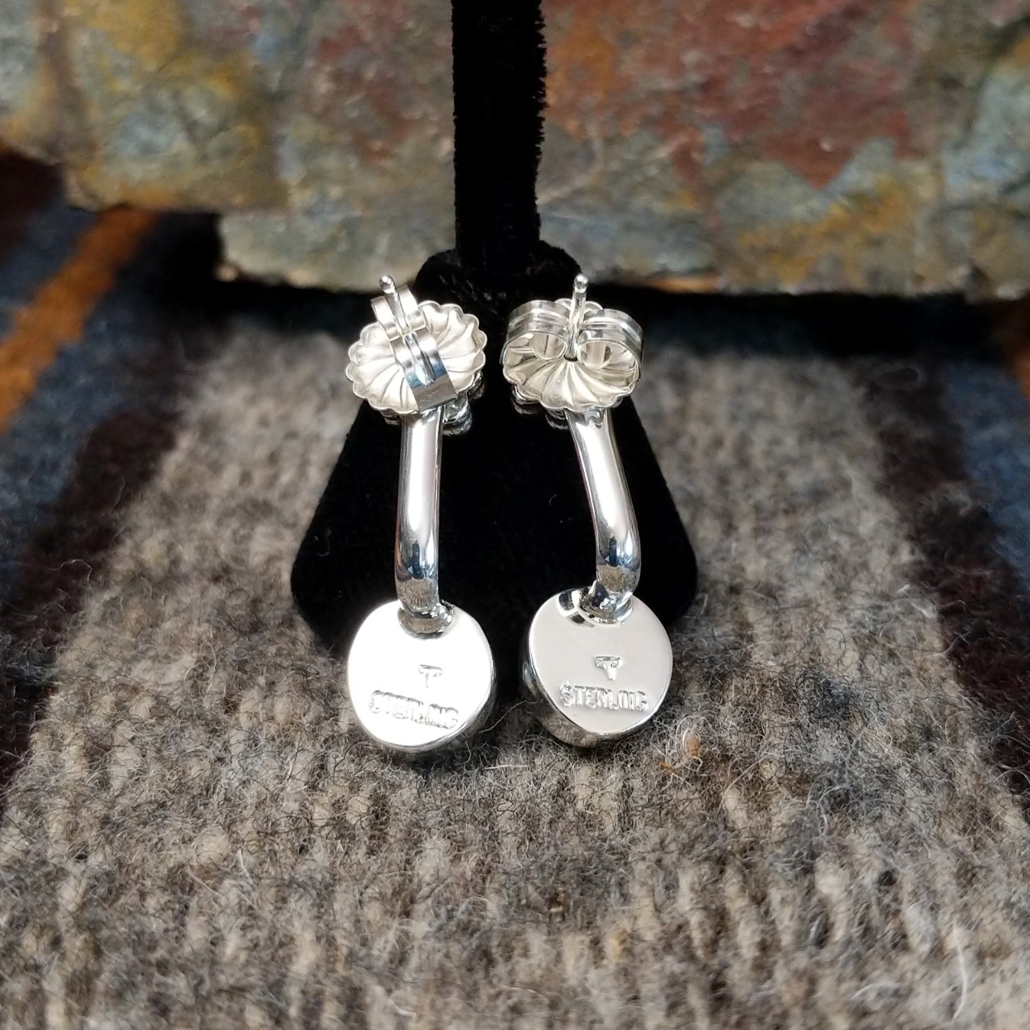 Stamped view of Golden Hills turquoise adjustable earrings showing the sterling silver backing with a signature mark by Navajo artist Terry Wood.