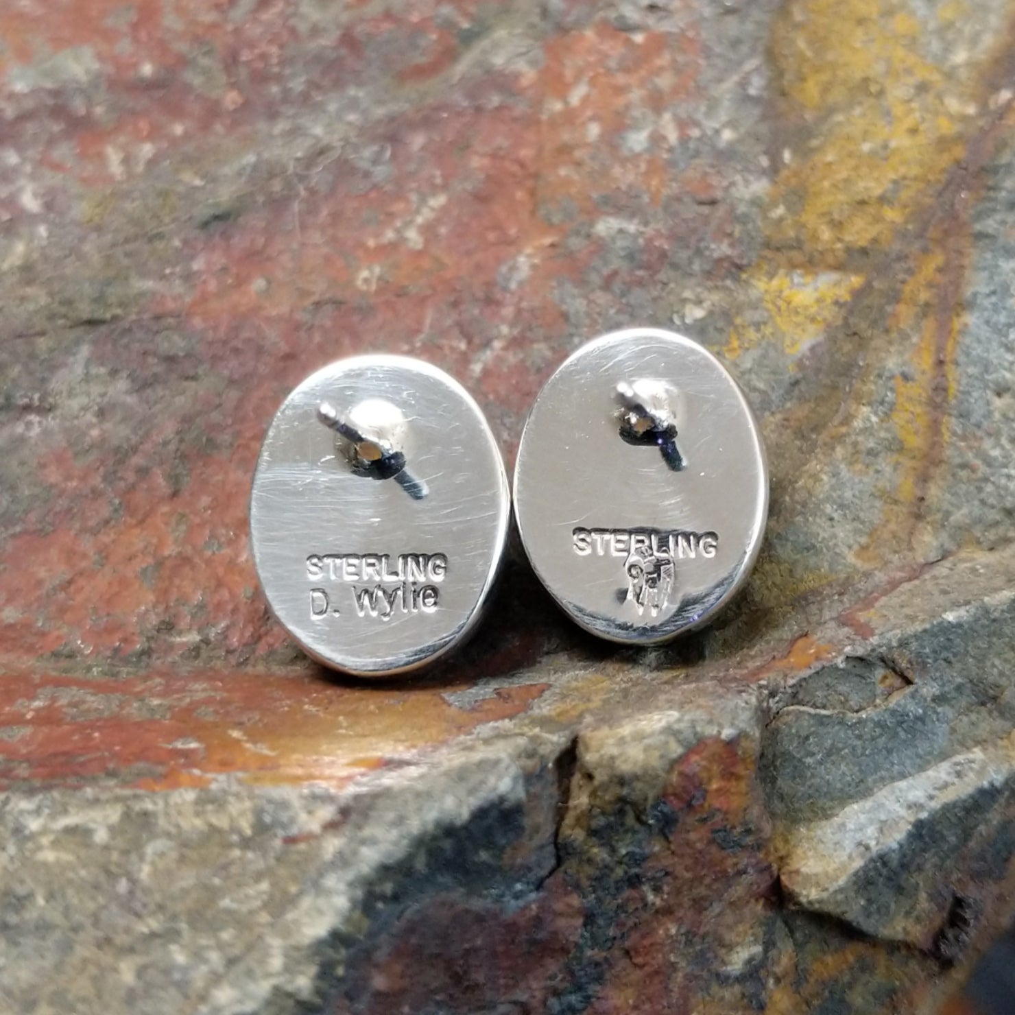The stamped/signature view of the golden hills turquoise oval earrings features a small hallmark near the post, marking Diane Wylie’s artistry.
