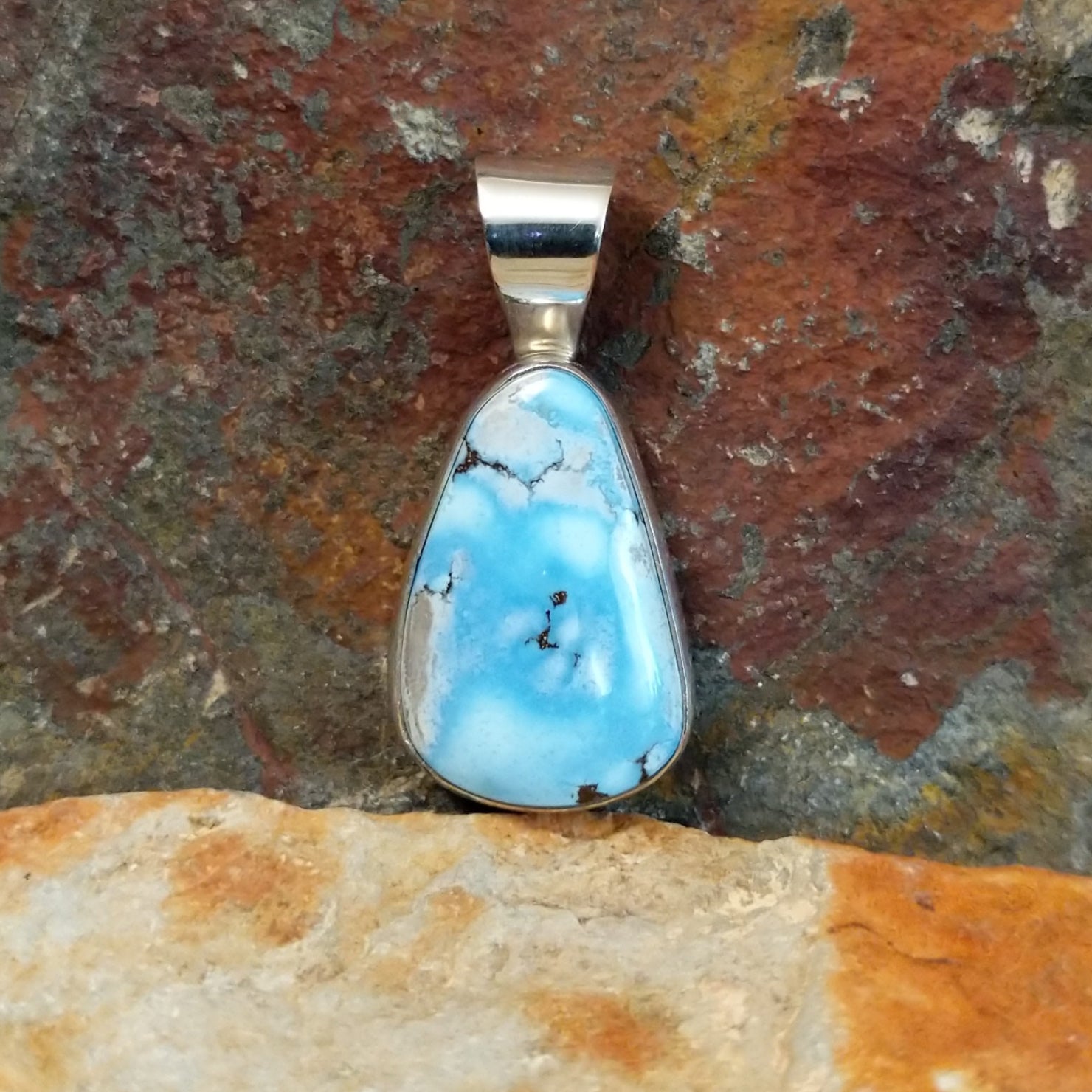 A sterling silver pendant features a Golden Hills turquoise stone in a smooth bezel.