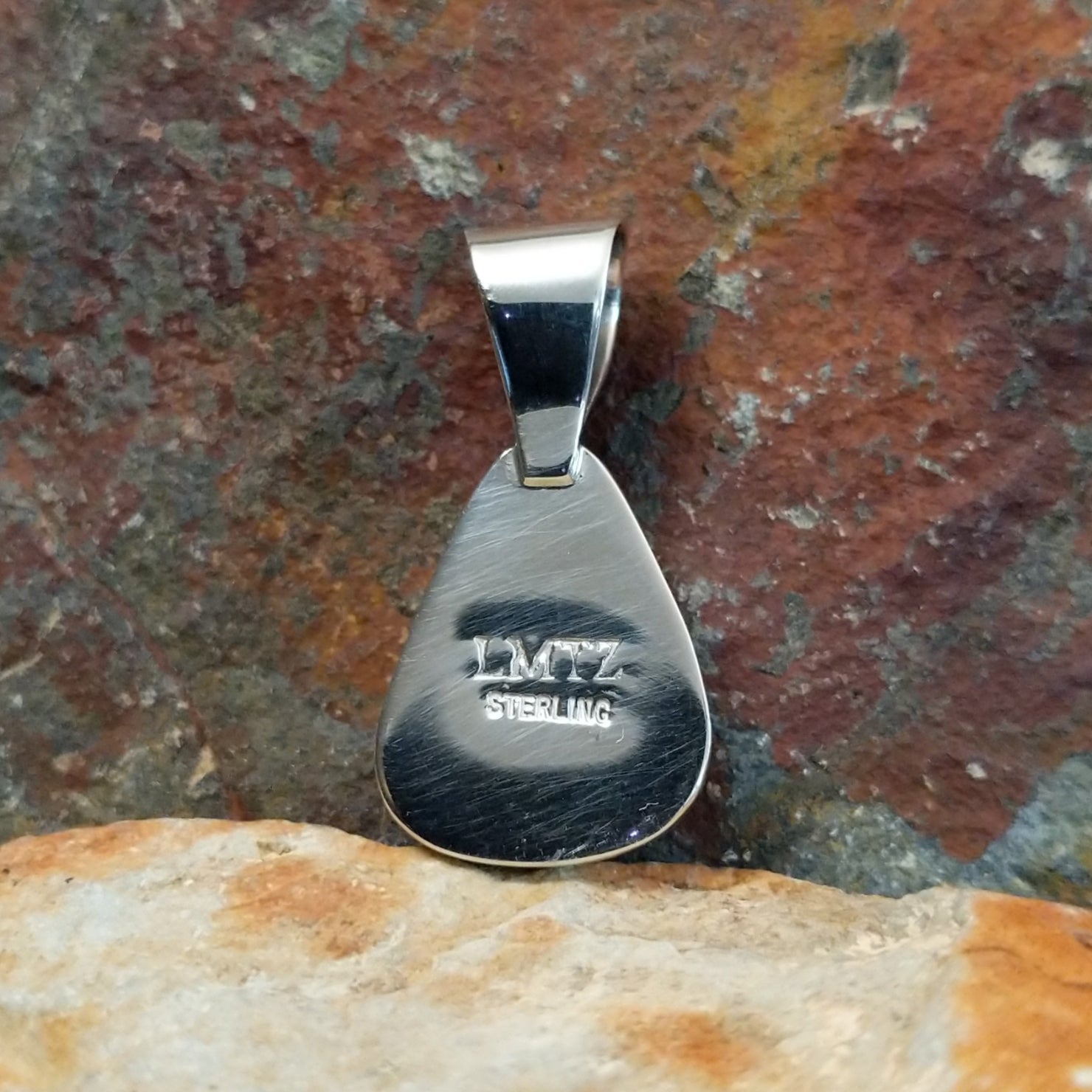 The back view shows the stamp and signature on the back of the sterling silver pendant.