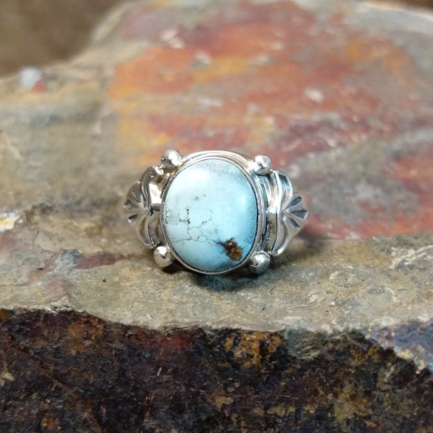 Silver ring with a round Golden Hills turquoise stone in a smooth bezel, adorned with decorative silver accents.