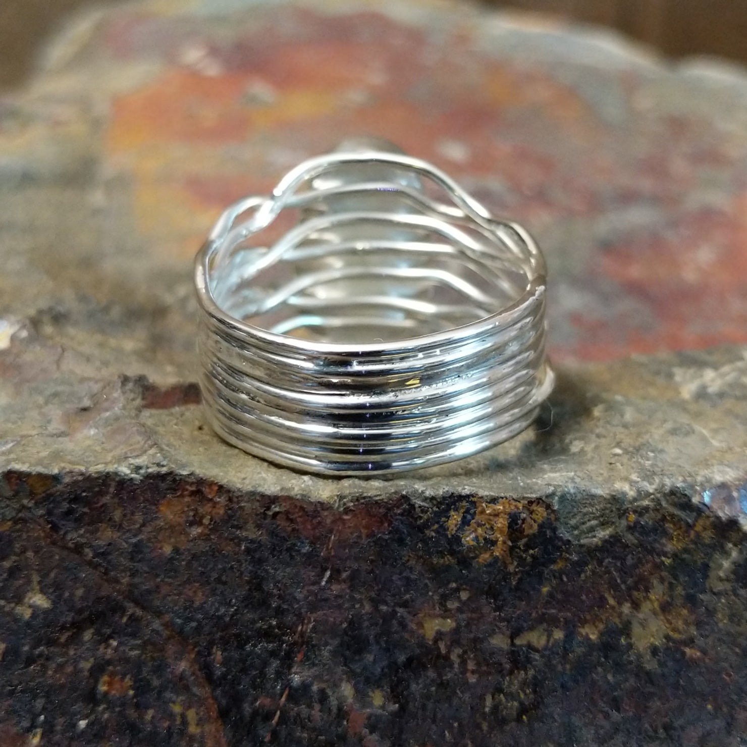 Silver ring with a twisted band, no stone visible, finished in a sleek silver tone.