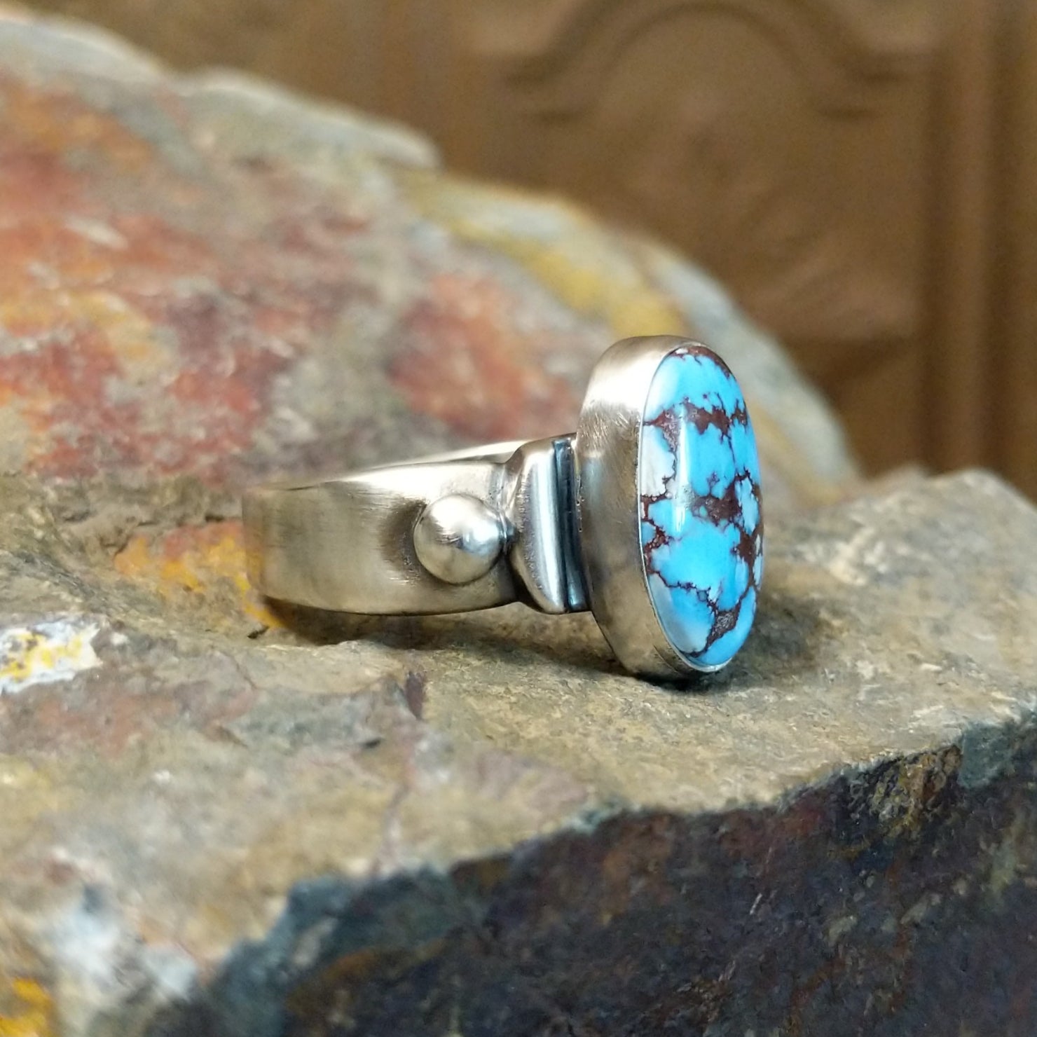 The ring’s band features polished silver with subtle silver ball accents.
