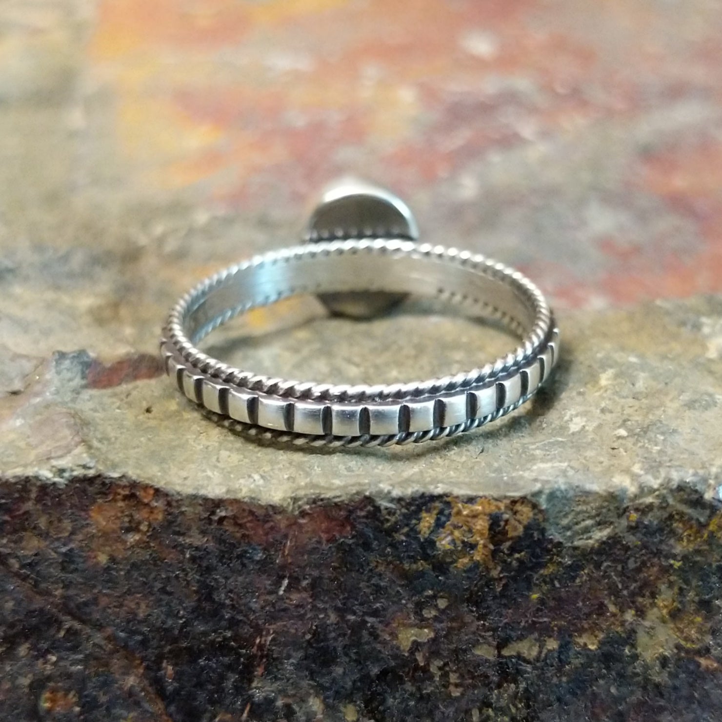 Silver ring with a plain twisted, ribbed band, no stone visible.