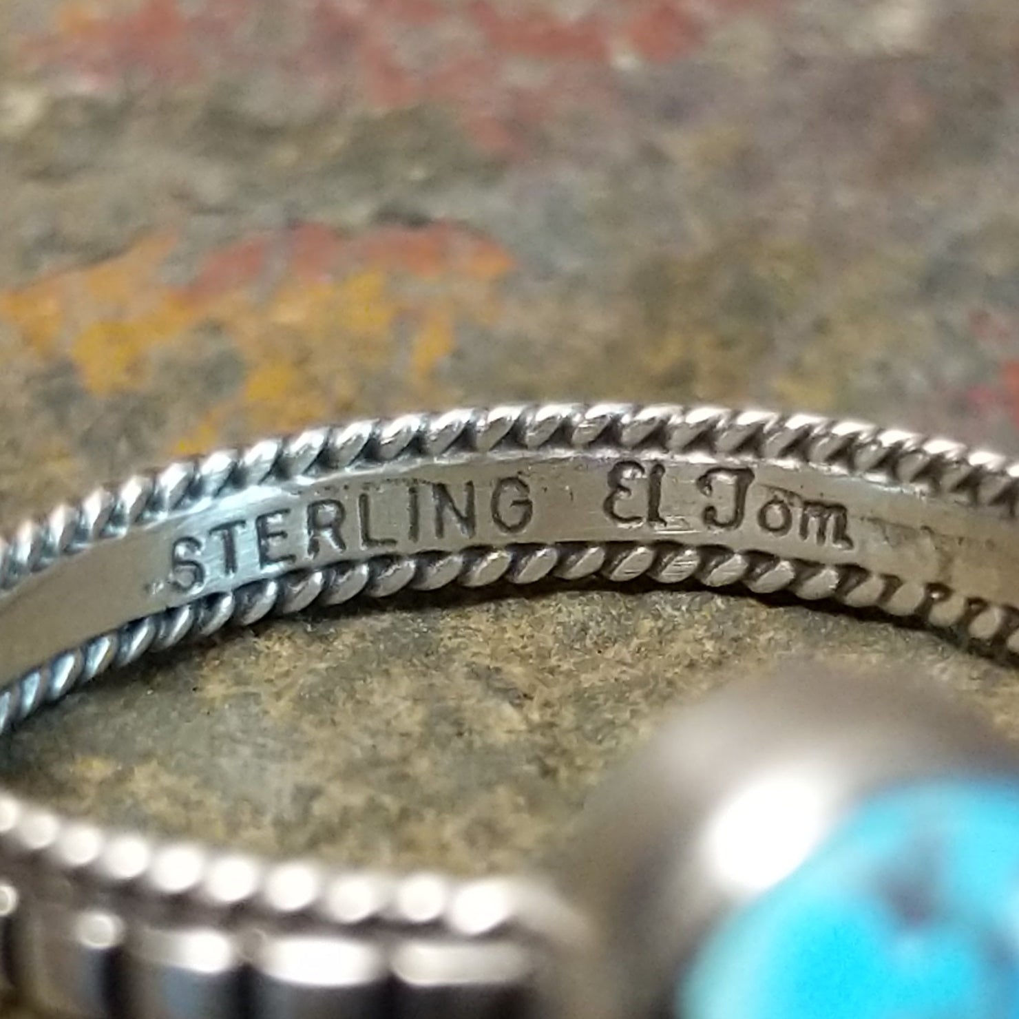 Silver ring with signature on the inner band, no stones or decoration present.