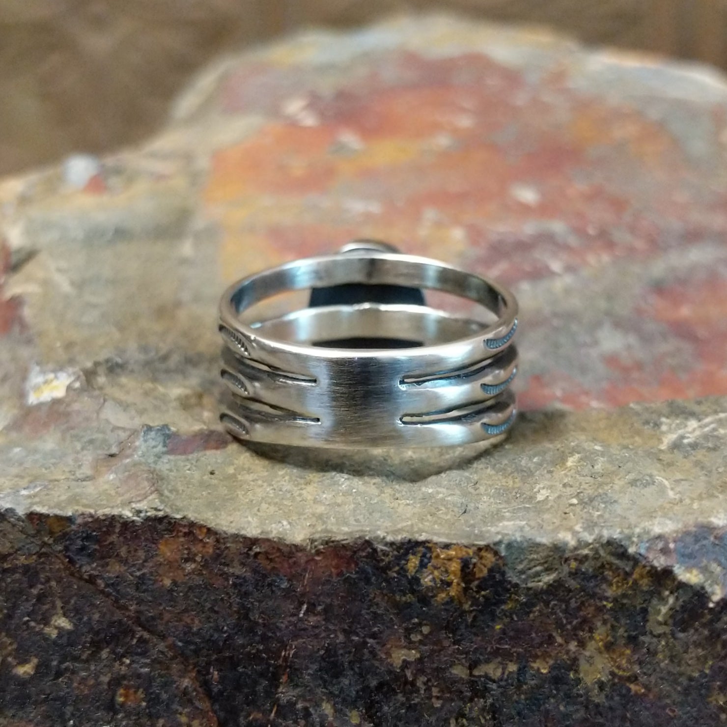 The ring’s silver back shows a subtle brand stamp, blending seamlessly with the design.
