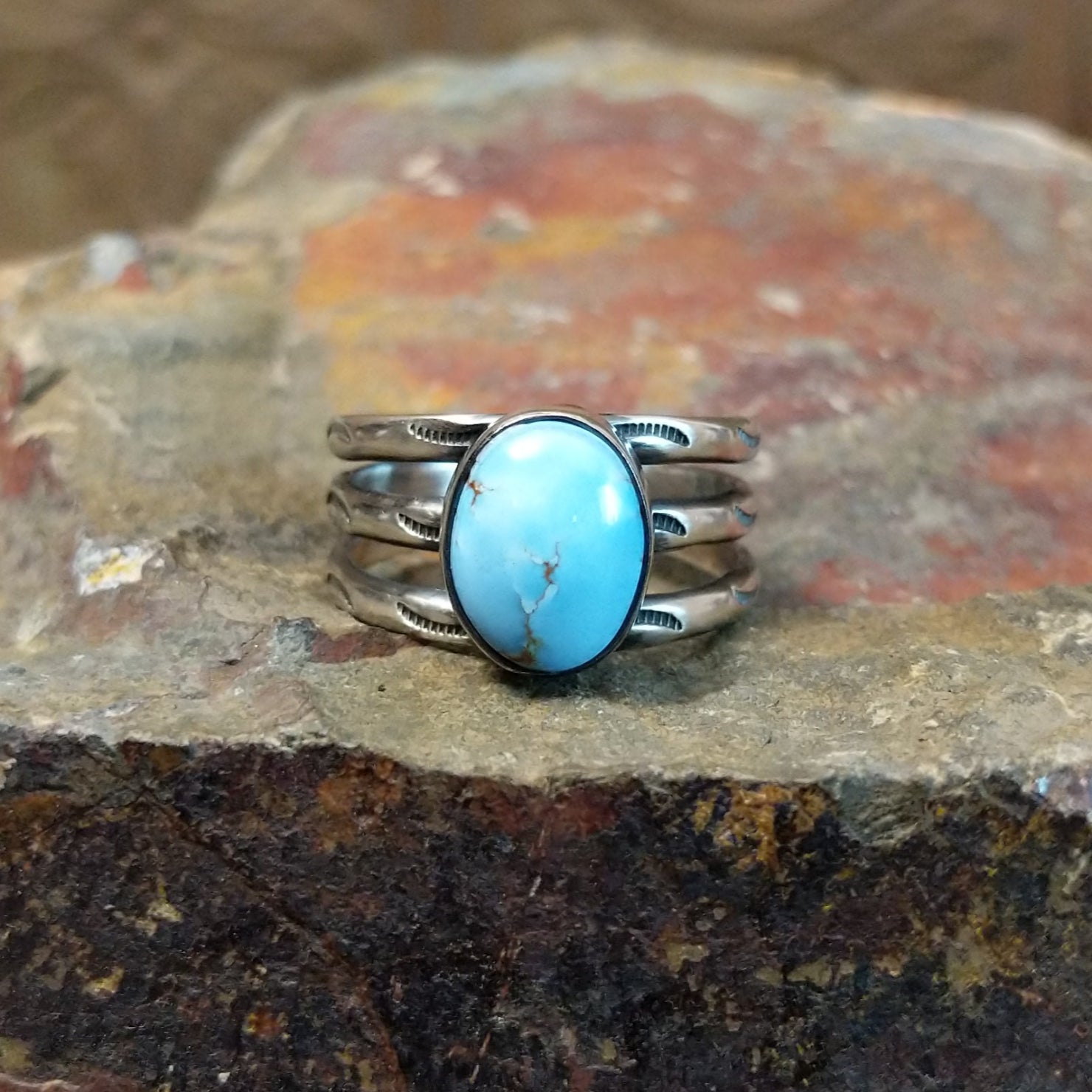 Golden Hills turquoise stone with subtle matrix veining sits in a smooth silver bezel, framed by ribbed bands.