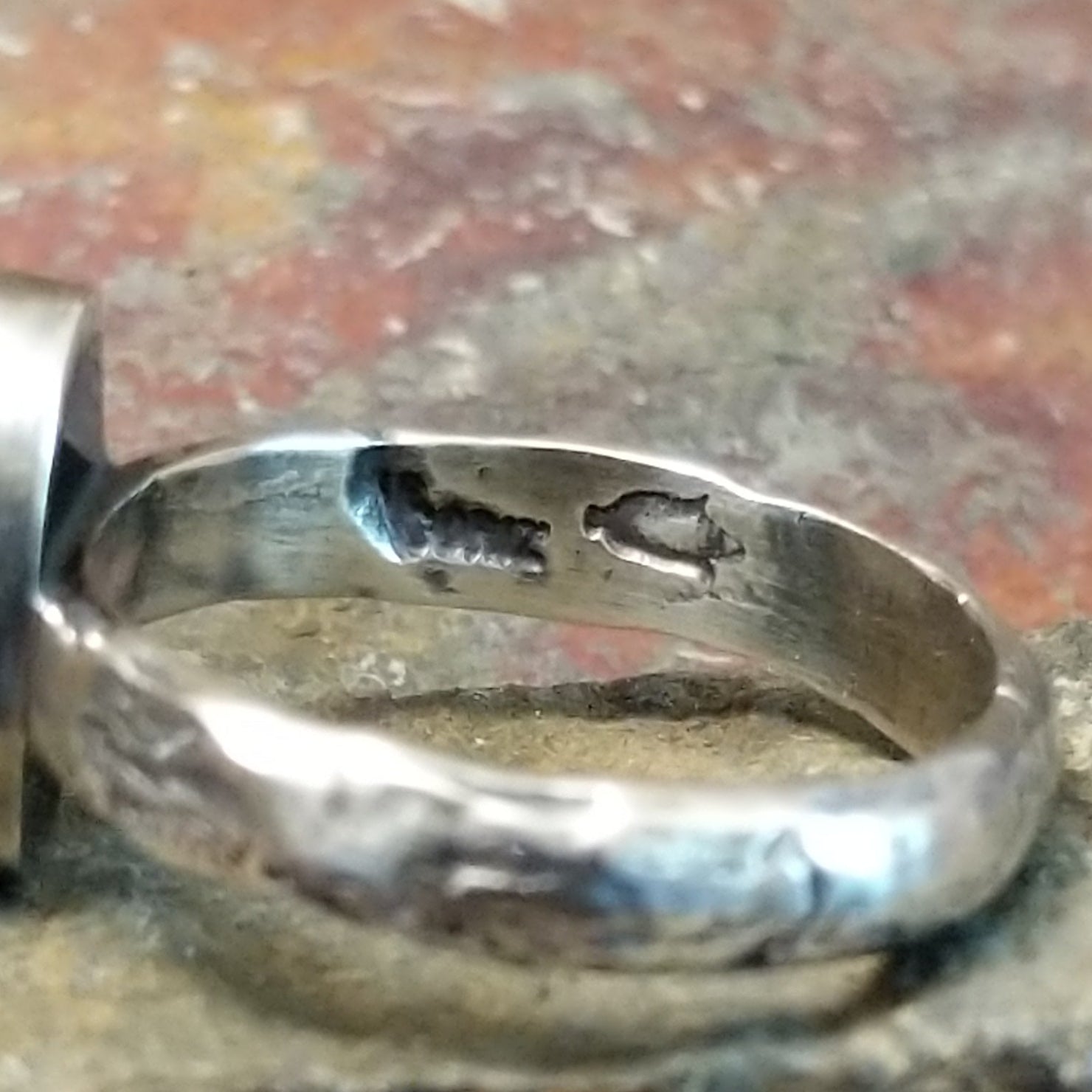 A clear signature is etched into the silver.