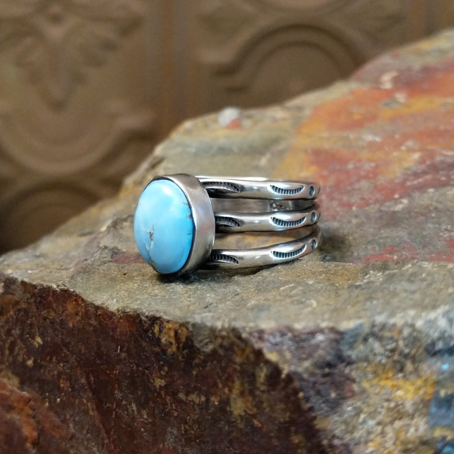 The ring’s multi-band design showcases polished silver with ribbed detailing.