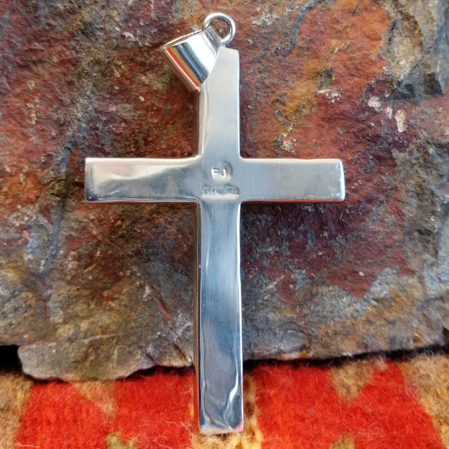 Grooved sterling silver cross pendant with single turquoise stone by Navajo artisan Francis Jones, showing artisan hallmark