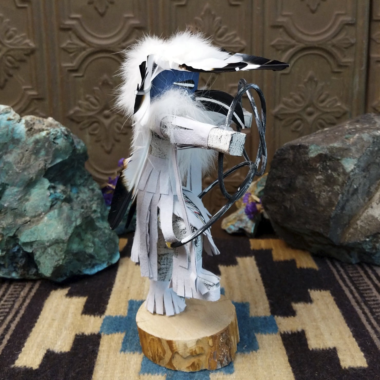 Navajo-made hoop dancer kachina doll by M. C. with blue mask, white feathers, and interwoven black hoops.