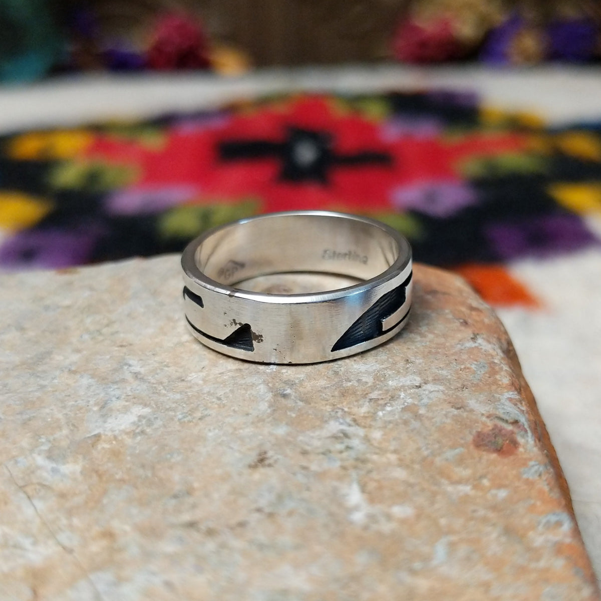 Hopi Silver Ring with a wide sterling silver band featuring a geometric overlay design, polished silver surfaces, and dark oxidized recessed details.