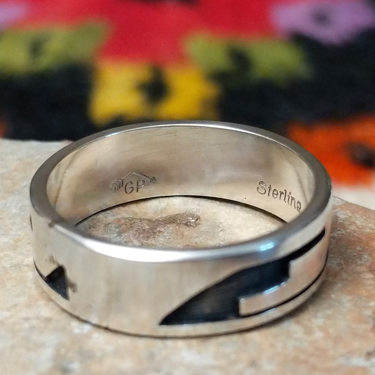 Hopi Silver Ring with a wide sterling silver band featuring a geometric overlay design, polished silver surfaces, and dark oxidized recessed details.