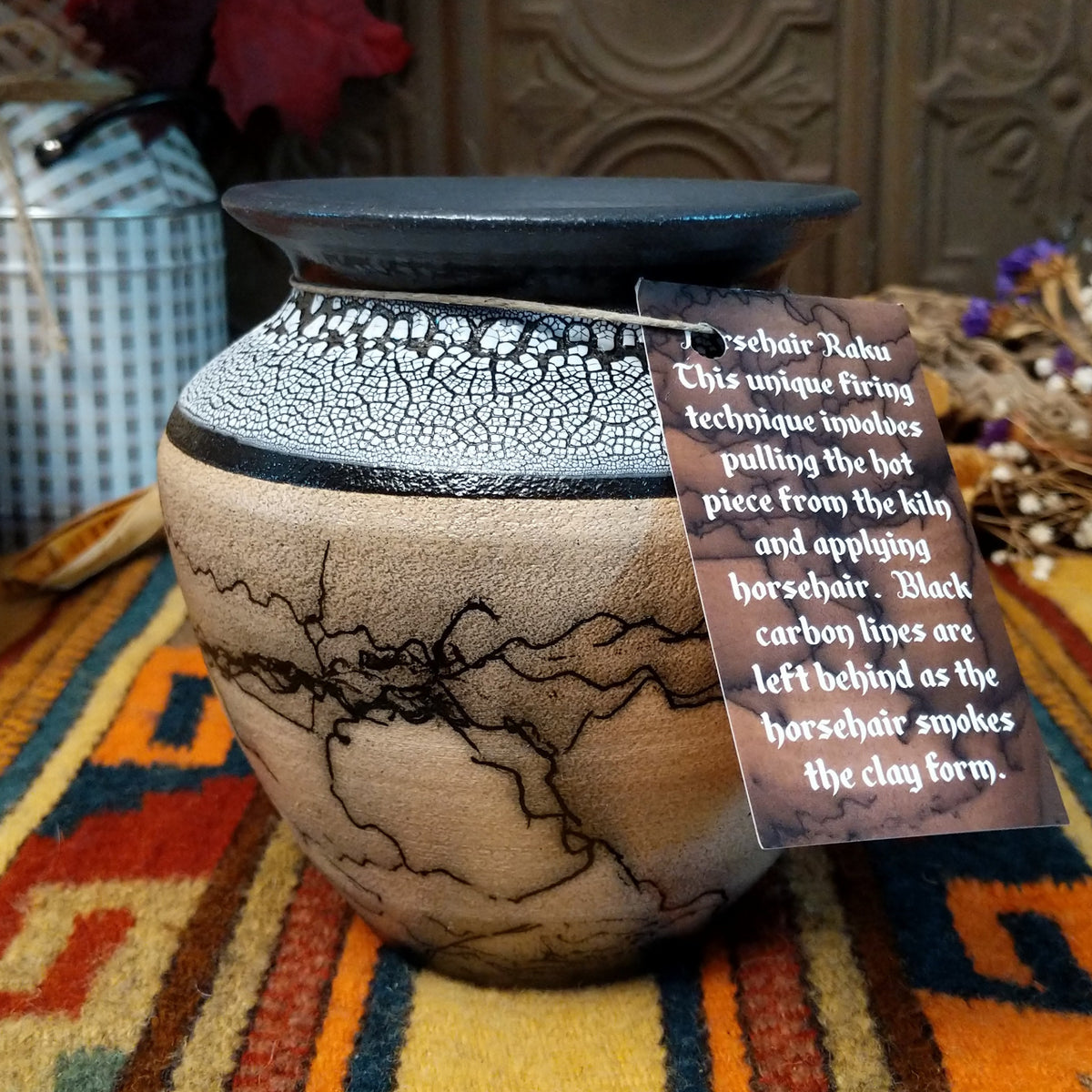 This distinctive Horsehair Pottery by Roger Calhoun features a rounded ceramic vessel with natural earth tones, delicate black horsehair patterns, a decorative crackled upper section, and a wide black rim.