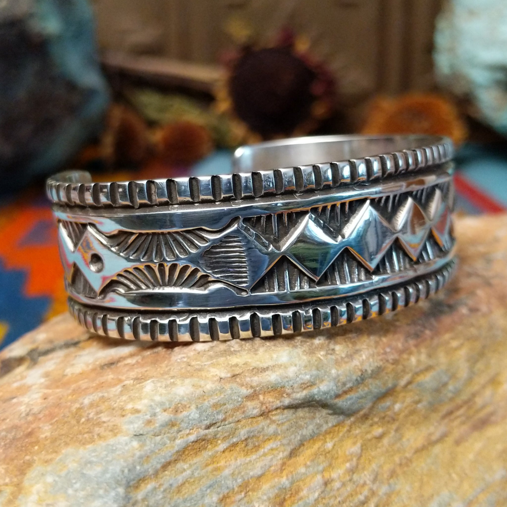 Wide silver cuff by Elvira Bill with repeating zigzag design, stamped accents, and detailed borders.