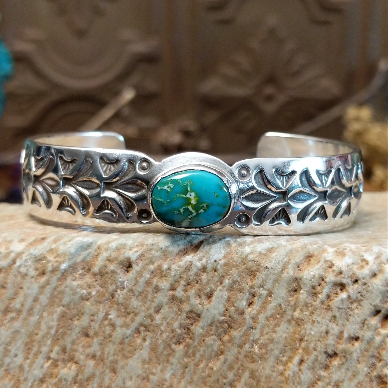Sterling silver cuff with Sonoran gold turquoise set in an oval bezel and floral stamping along the surface of the band.