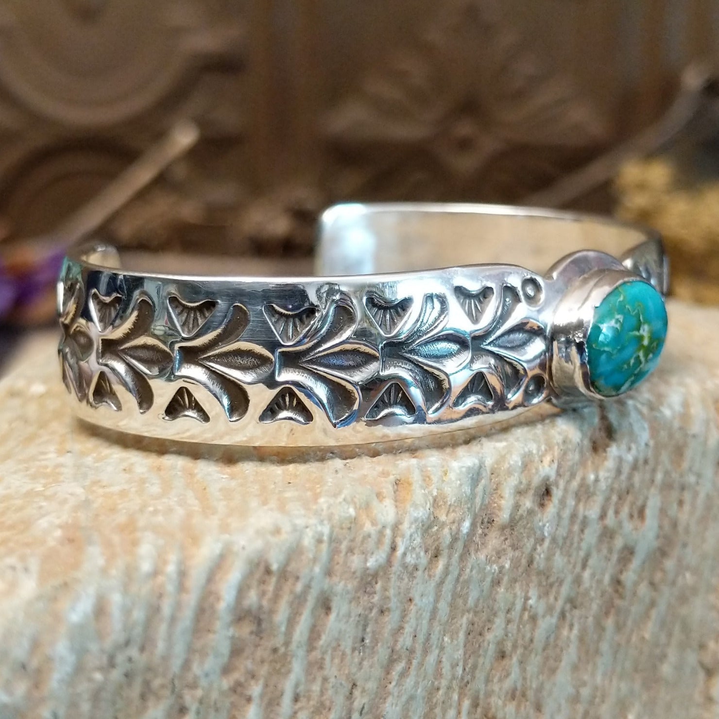 Sterling silver cuff with Sonoran gold turquoise set in an oval bezel and floral stamping along the surface of the band.