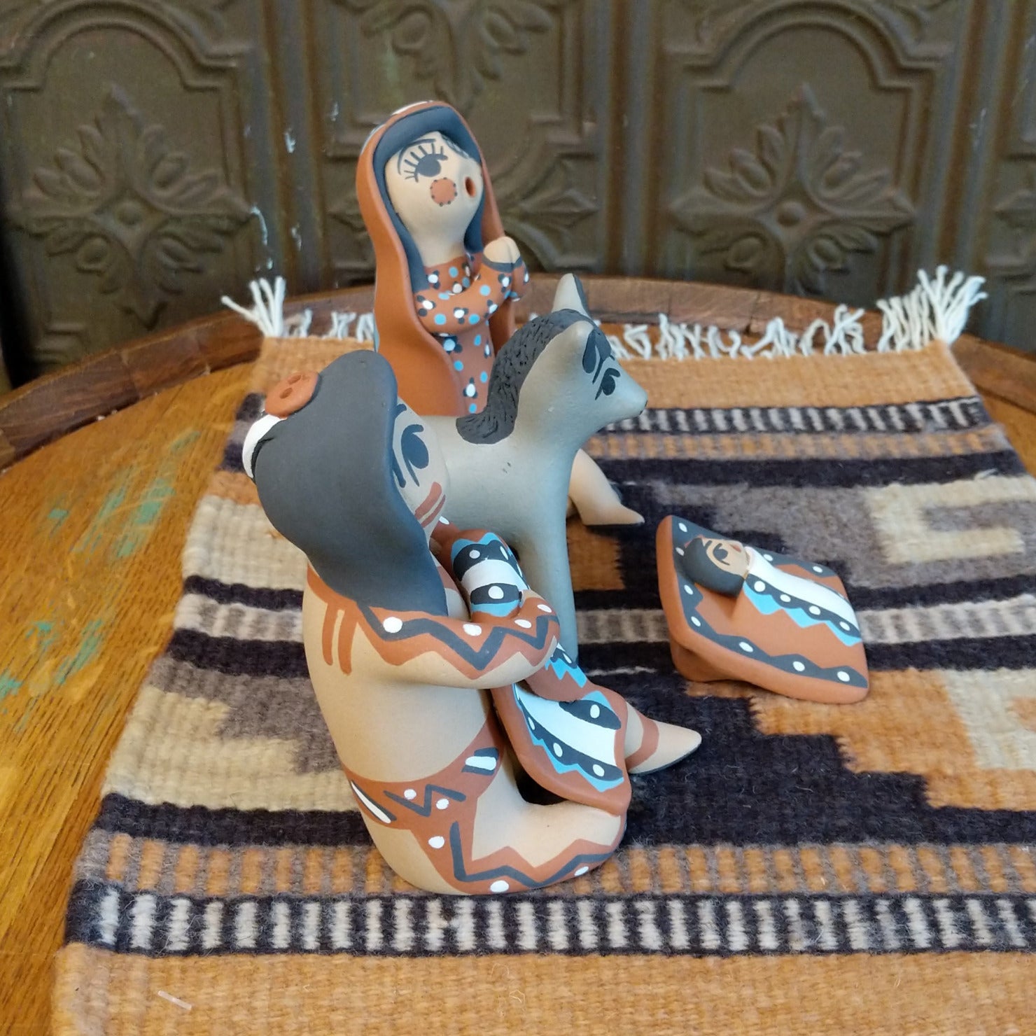 Clay made into a mother, father, baby, and donkey and are painted in various colorful designs.