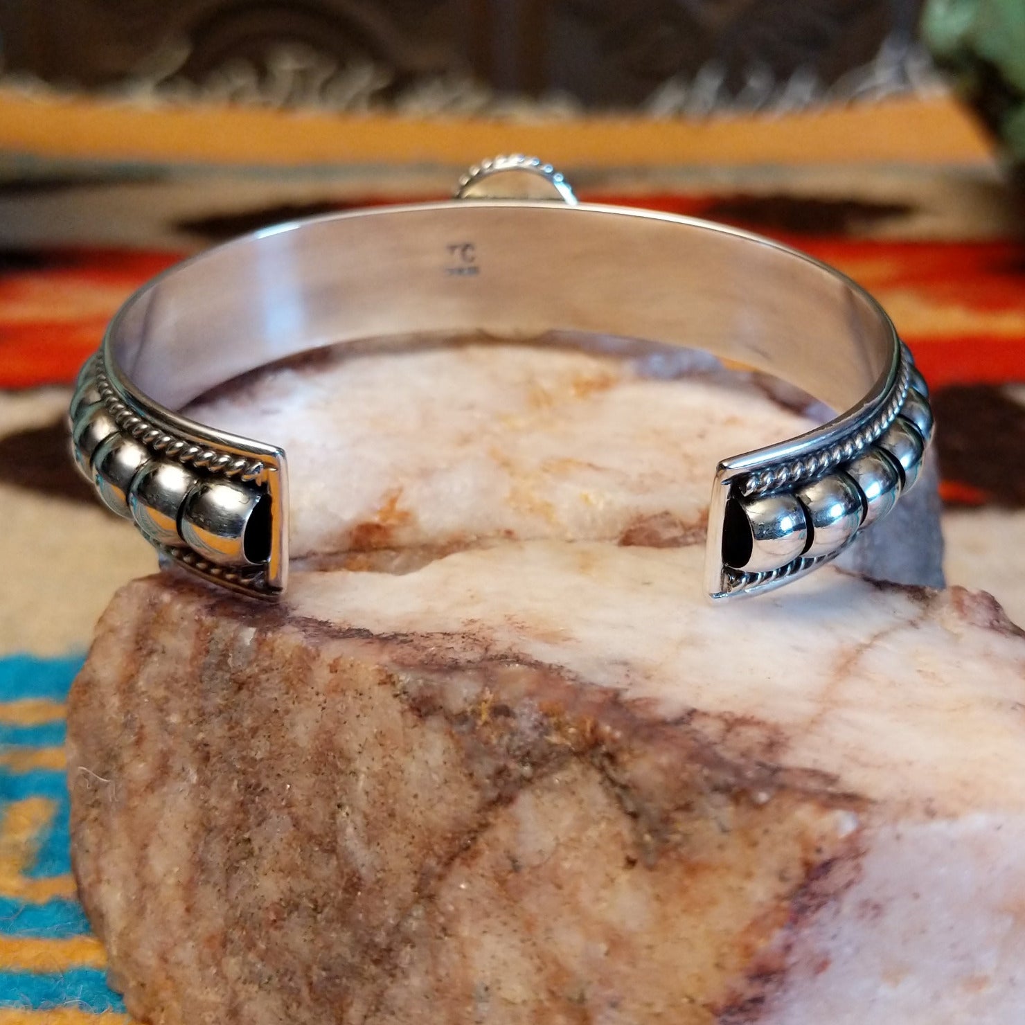 Sterling silver cuff bracelet with Kingman turquoise set in the round bezel and twisted rope with ornate silverwork accents.