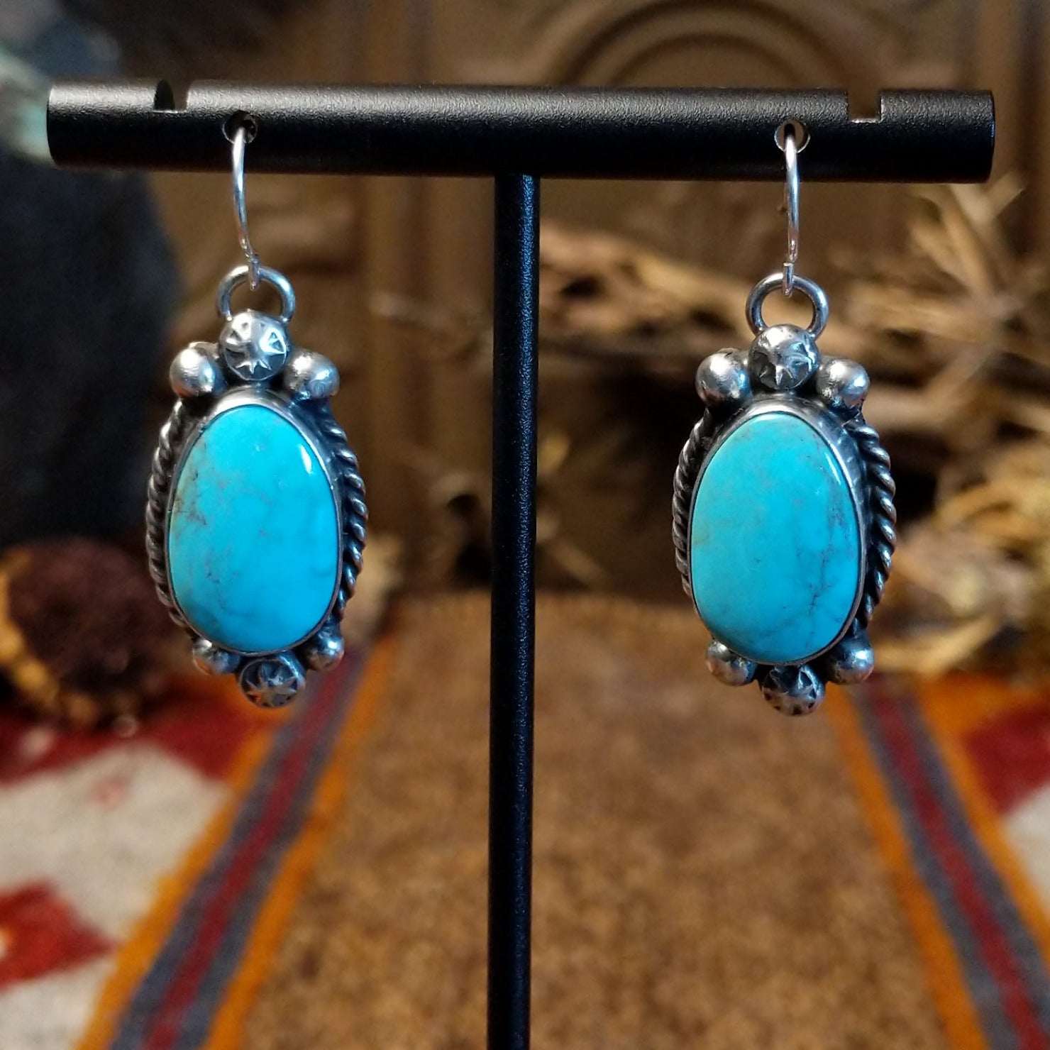 Sterling silver earrings with kingman turquoise set in the bezels, framed by twisted rope and dotted accents.