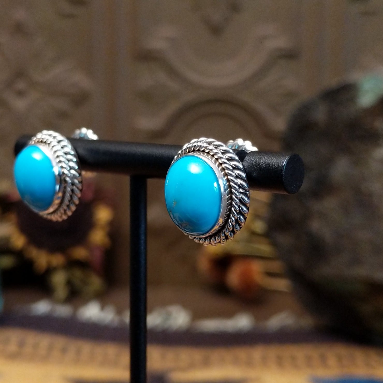 Sterling silver Kingman Turquoise stud earrings featuring oval blue stones with twisted rope borders.