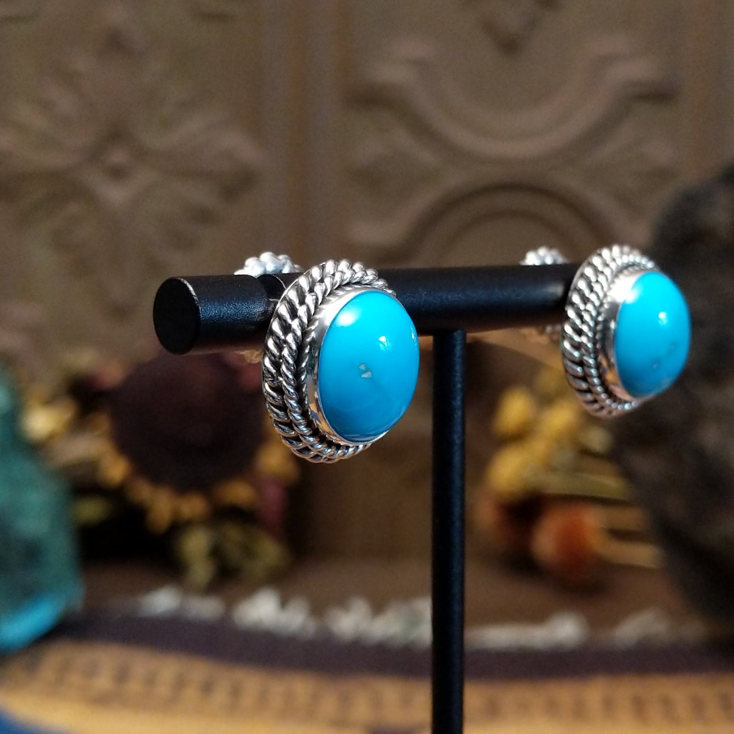 Sterling silver Kingman Turquoise stud earrings featuring oval blue stones with twisted rope borders.