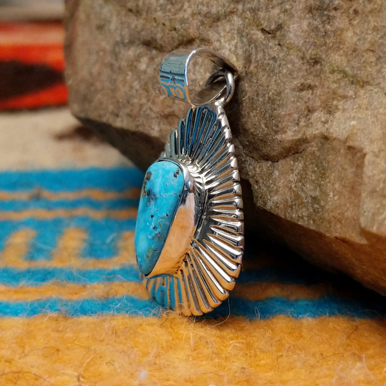 Sterling silver pendant with Kingman turquoise set in the triangular bezel, framed by the ray setting.