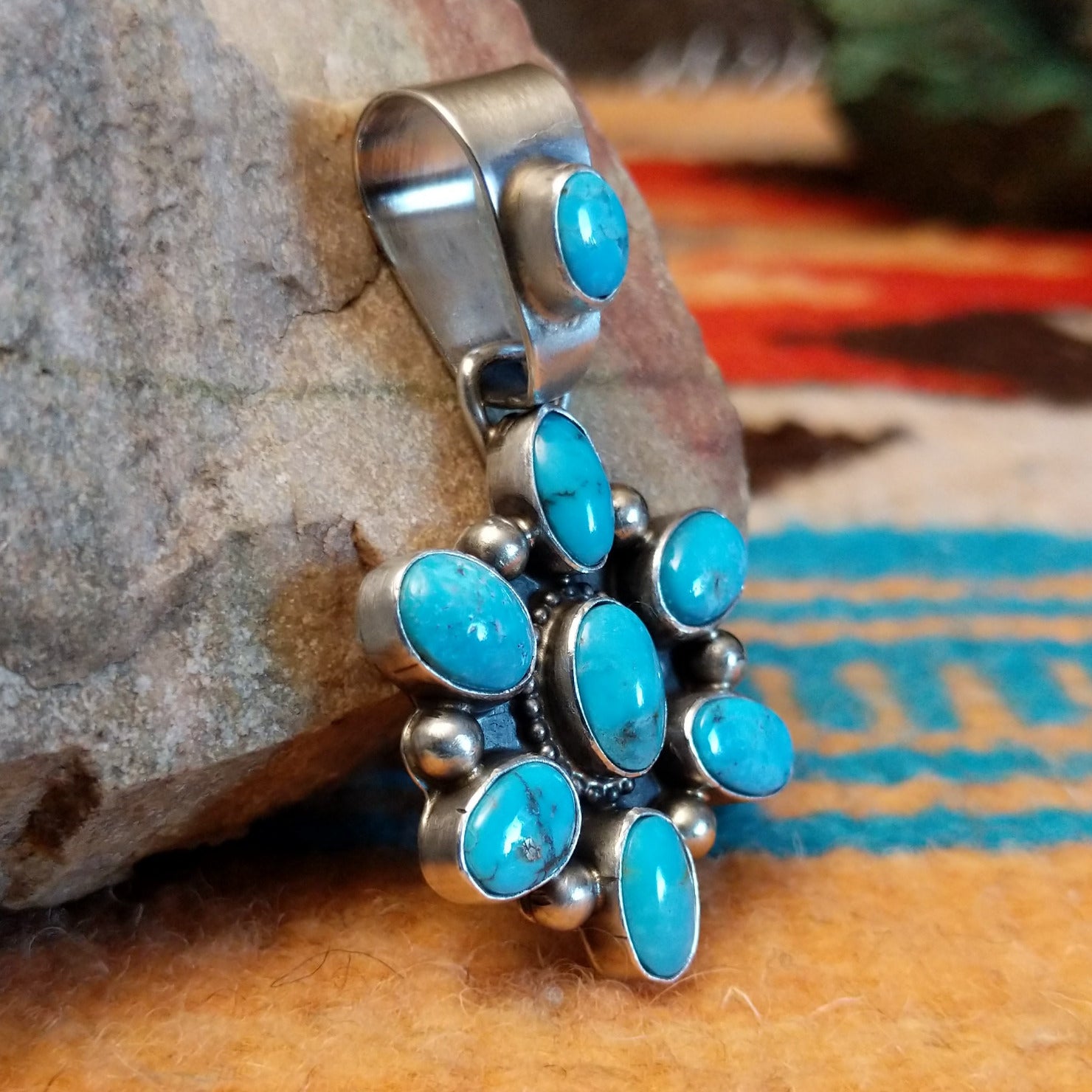 Sterling silver pendant with Kingman turquoise set in oval bezels that create a starburst design.