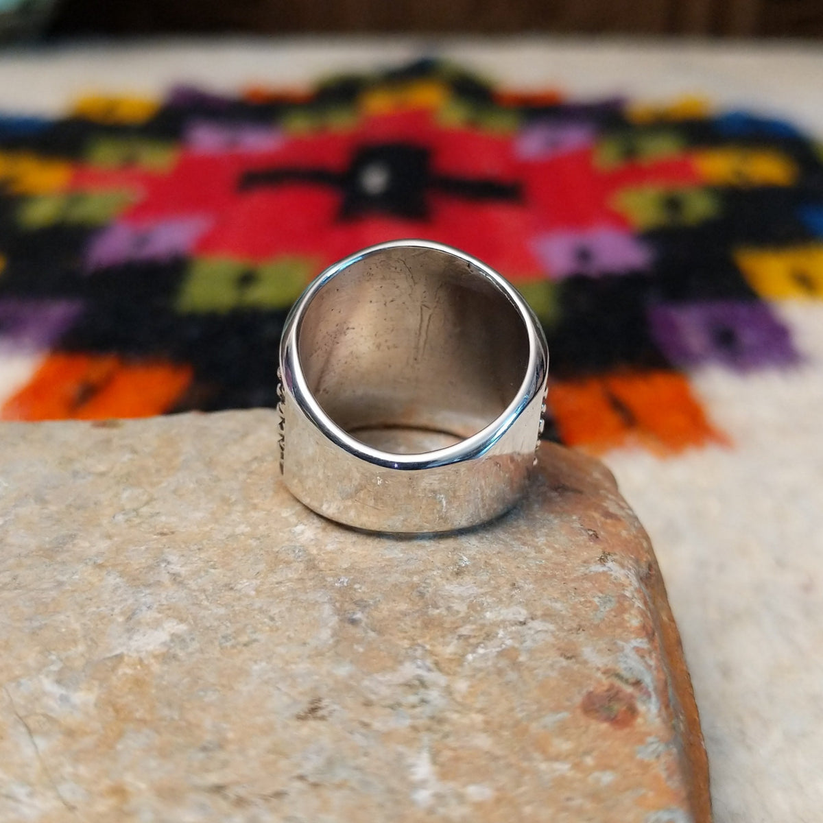 This distinctive Silver Ring by Raymond Coriz features a wide silver band with a raised crosshatch pattern, oxidized detailing, and smooth polished borders along the top and bottom; underside view.