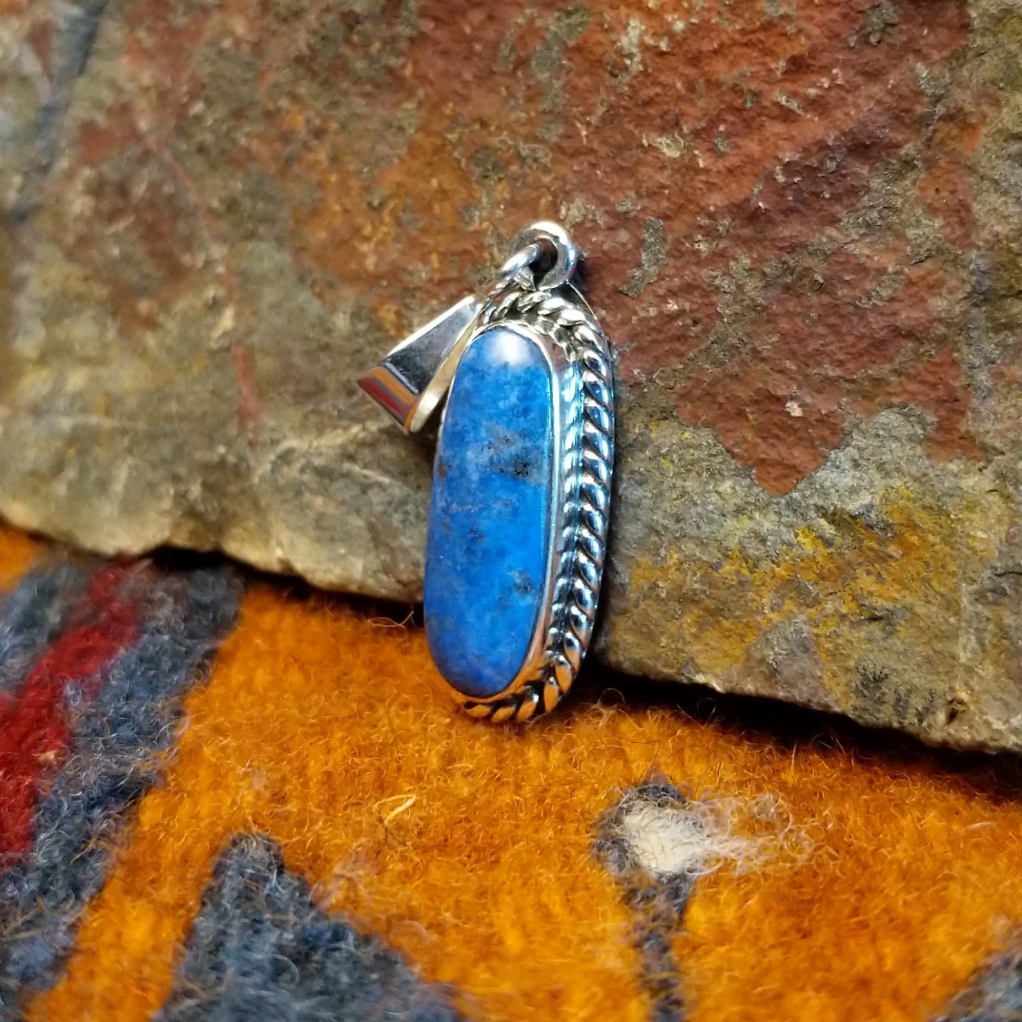 Sterling silver pendant with lapis set in the bezel, framed by twisted rope accents.