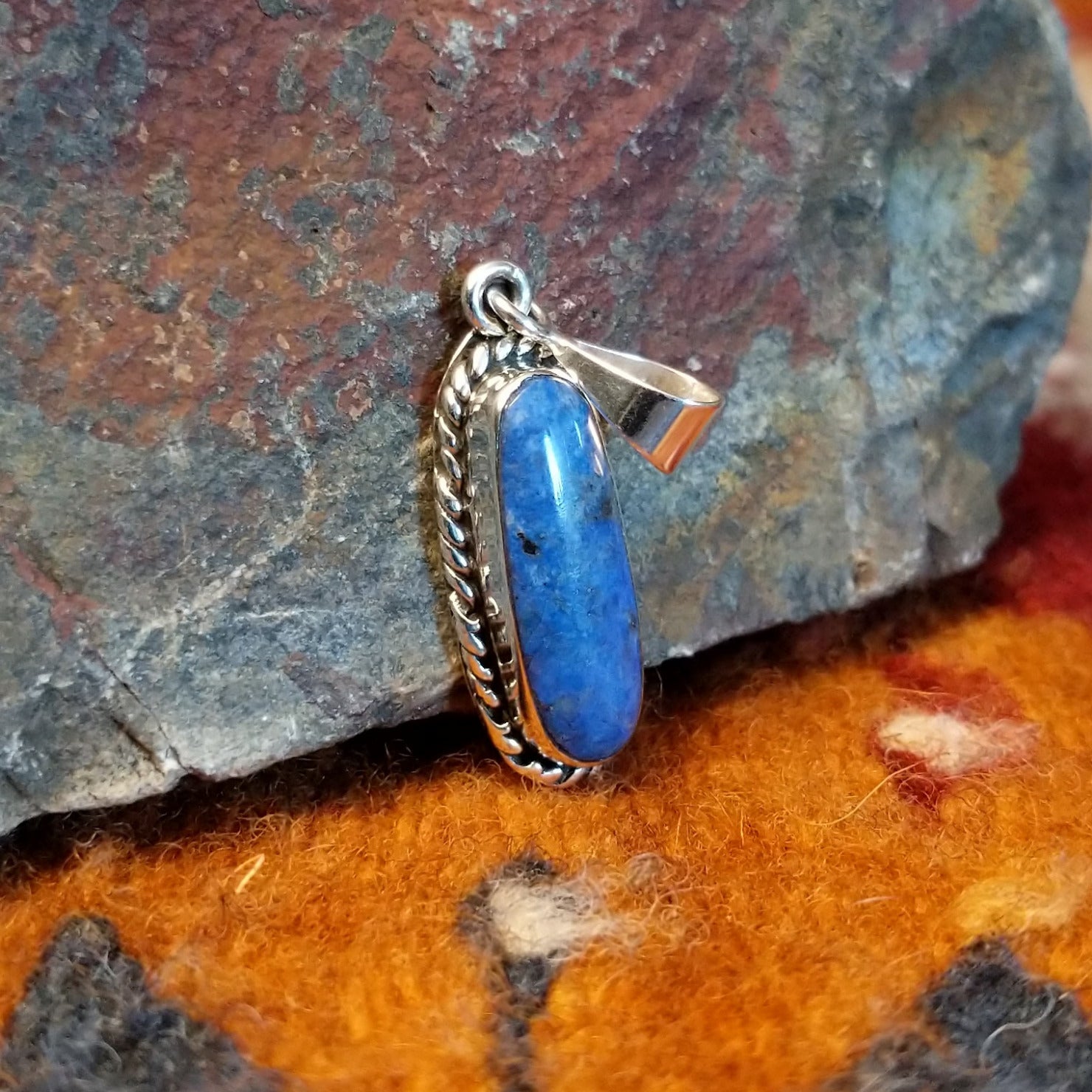Sterling silver pendant with lapis set in the bezel, framed by twisted rope accents.