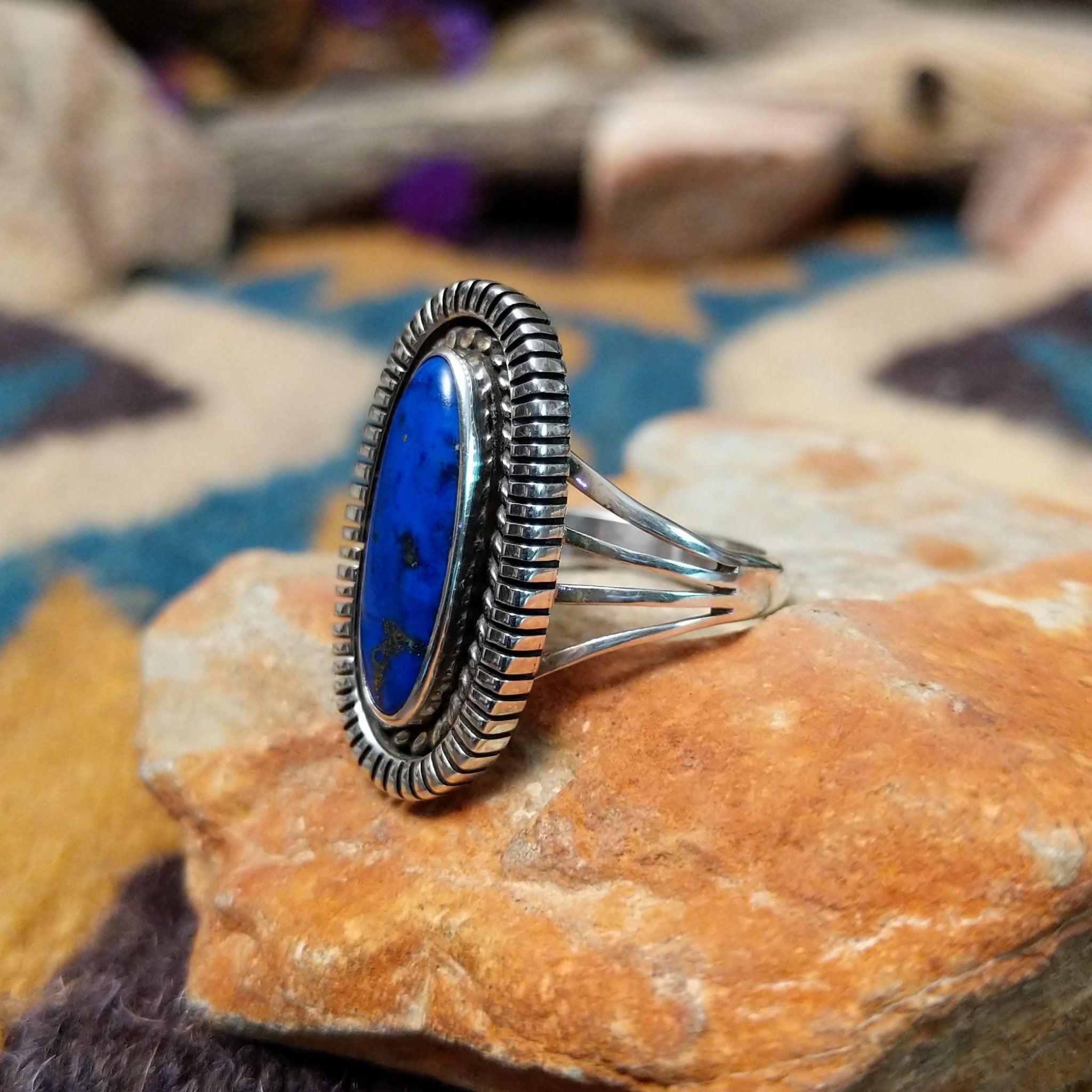Sterling silver Lapis Lazuli ring by Tim Bedah featuring a capsule-shaped deep blue stone with natural pyrite inclusions; side view.