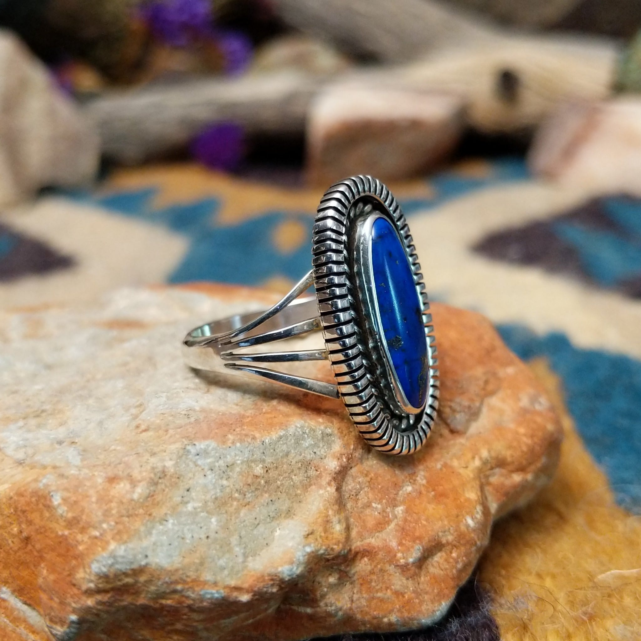 Sterling silver Lapis Lazuli ring by Tim Bedah featuring a capsule-shaped deep blue stone with natural pyrite inclusions; side view.