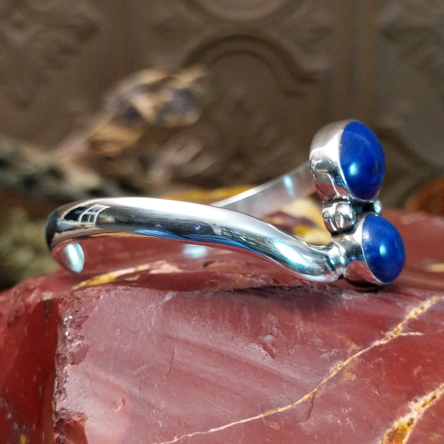 Sterling silver cuff bracelet with lapis set in a duo bezel, framed by dotted accents.
