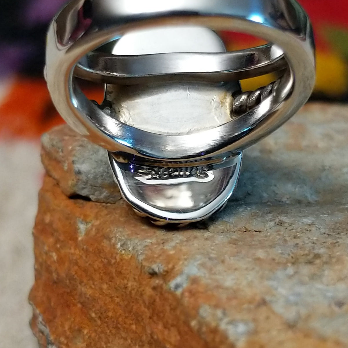 This striking Lapis Oval Ring by Raymond Coriz features an elongated deep blue lapis stone surrounded by twisted silver ropework, silver bead accents, and a polished split-shank band; Sterling Silver stamp.