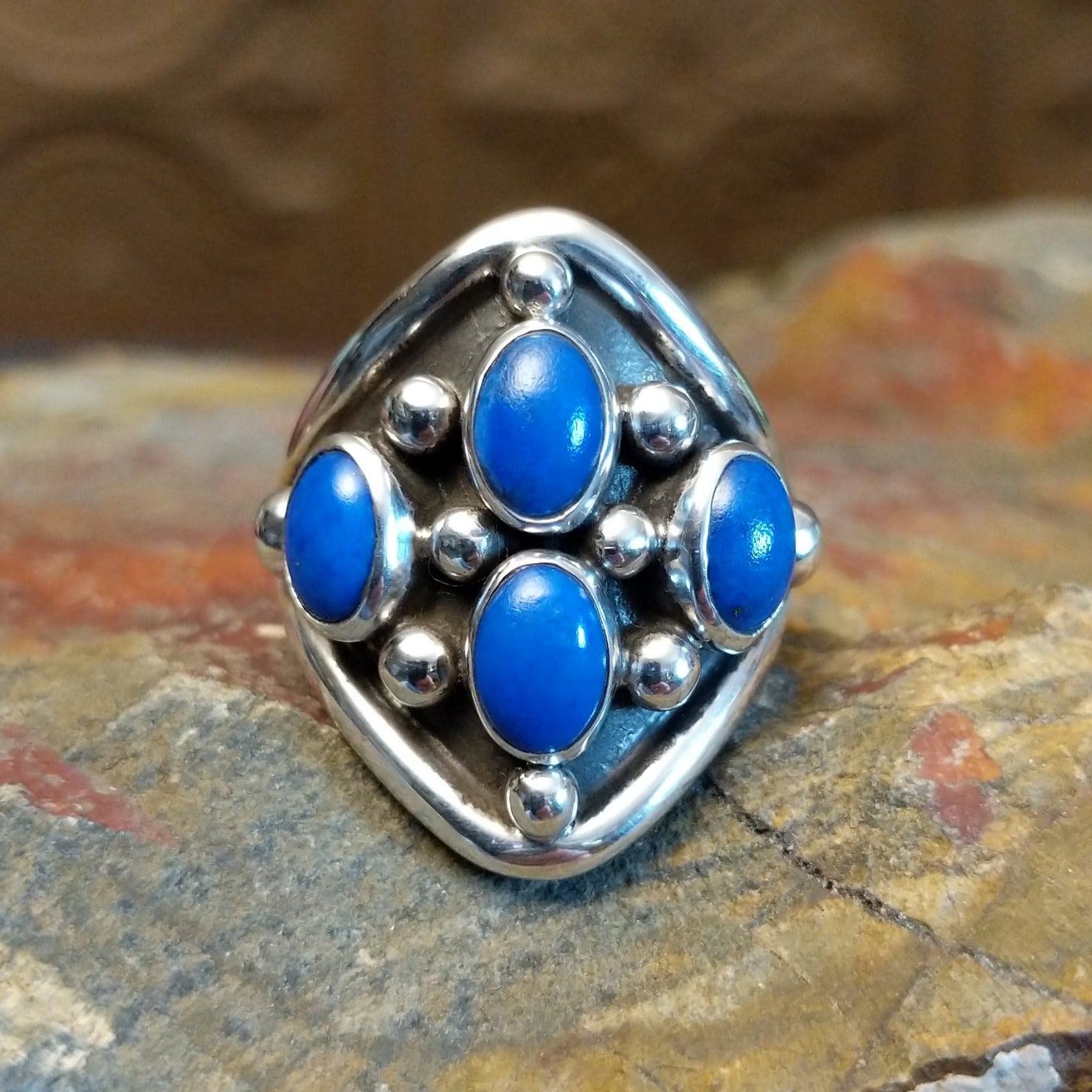 Sterling silver ring with lapis set in tetrad bezels along the surface and dotted accents.