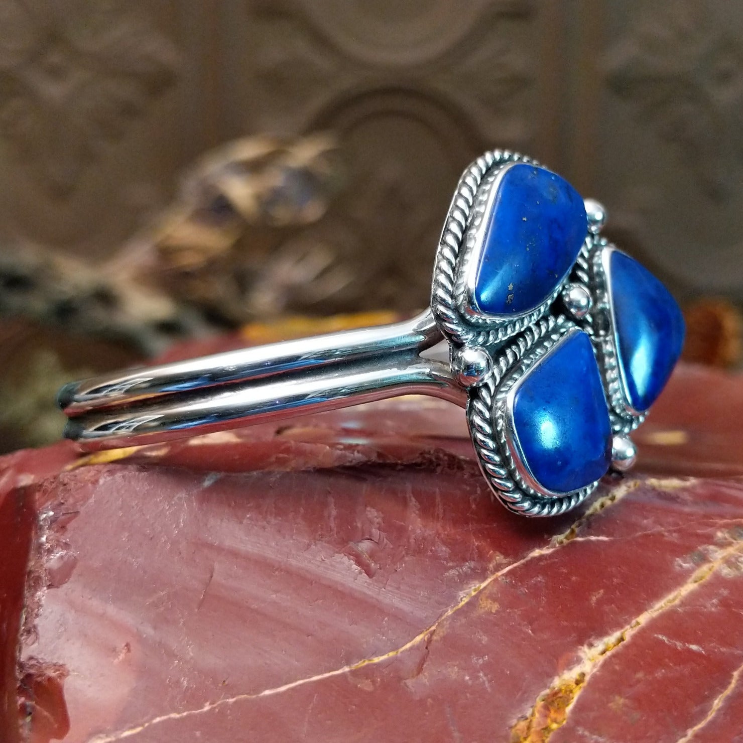 Sterling silver cuff bracelet with lapis set in a triad of bezels, framed by twisted rope accents.