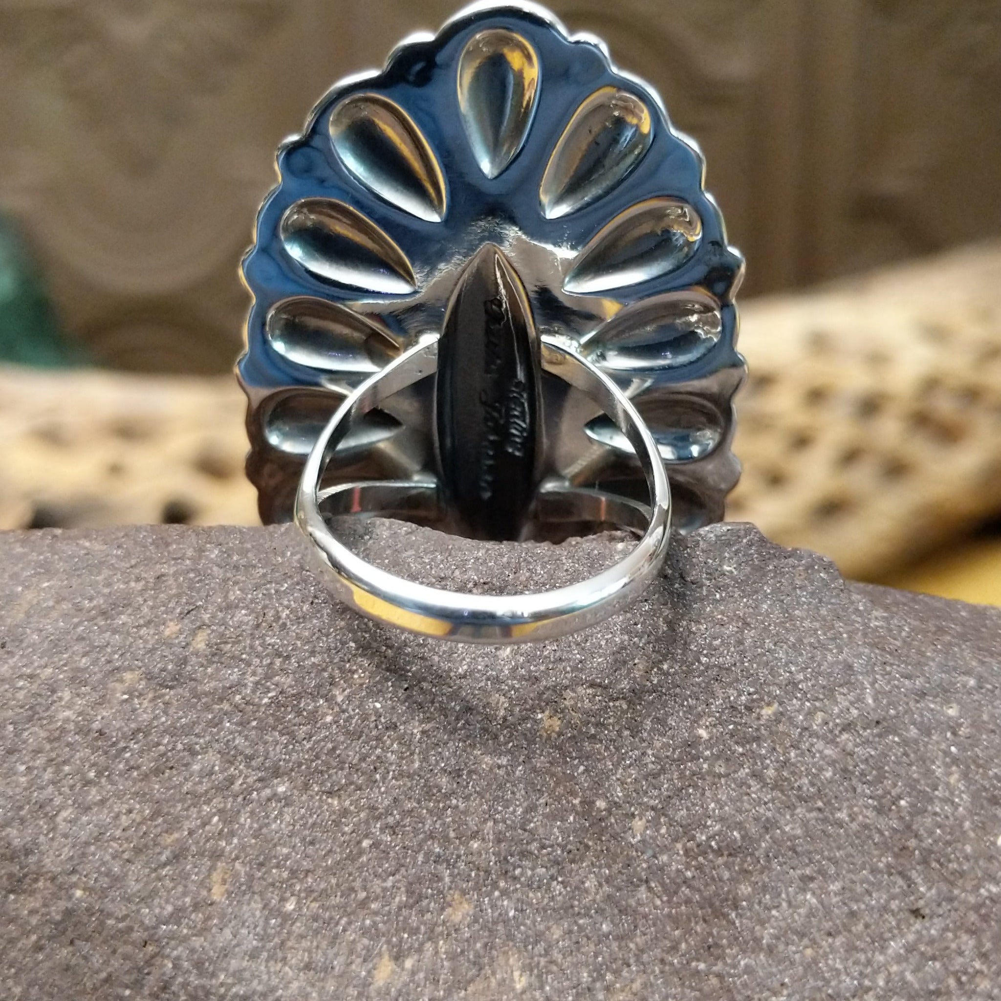 Large stamped sterling silver ring by Charles Johnson, featuring intricate hand-stamped patterns on a bold polished silver band with traditional Southwestern-inspired craftsmanship. Underside view.