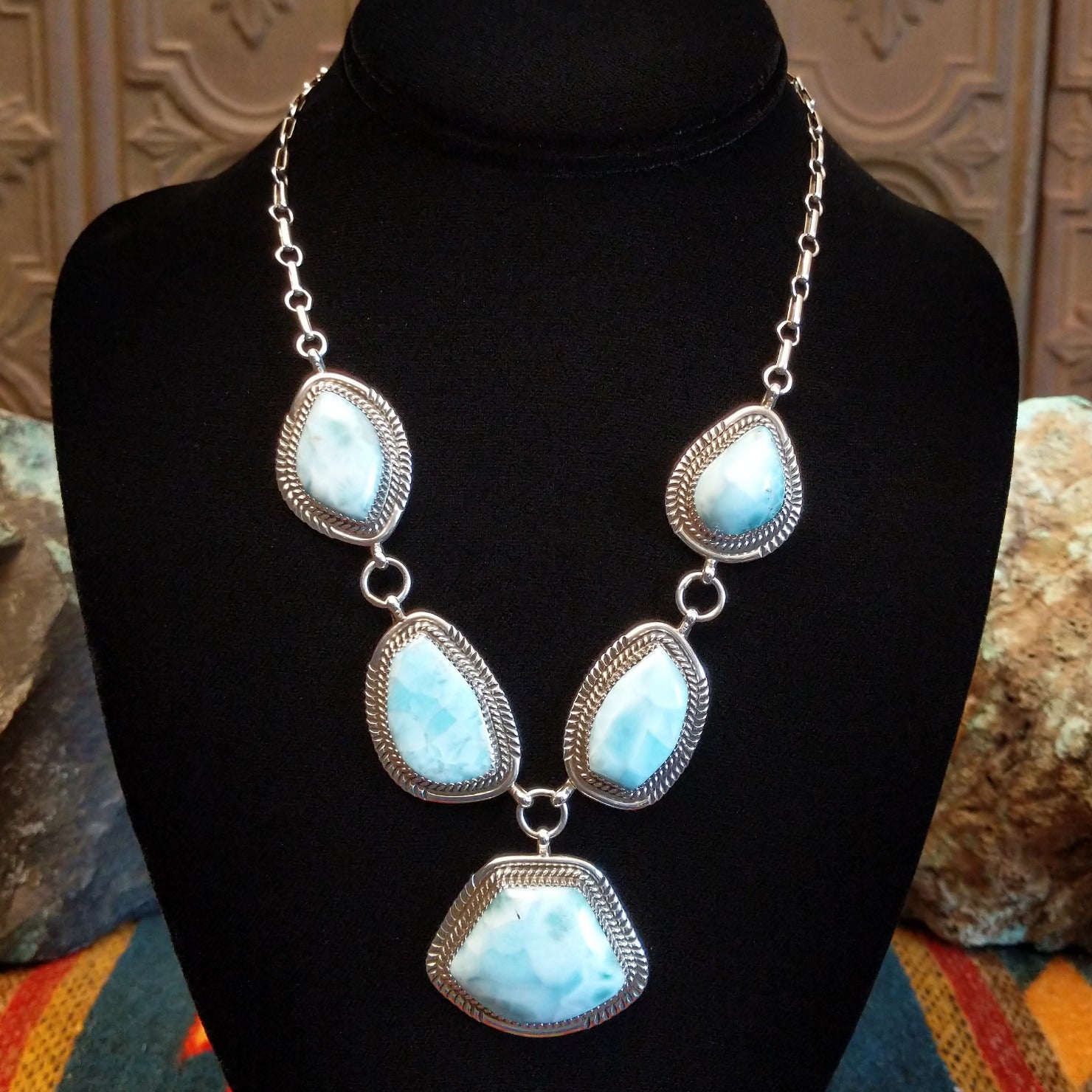 Sterling silver necklace with larimar set in geometric bezels, framed by twisted rope and stamped accents.