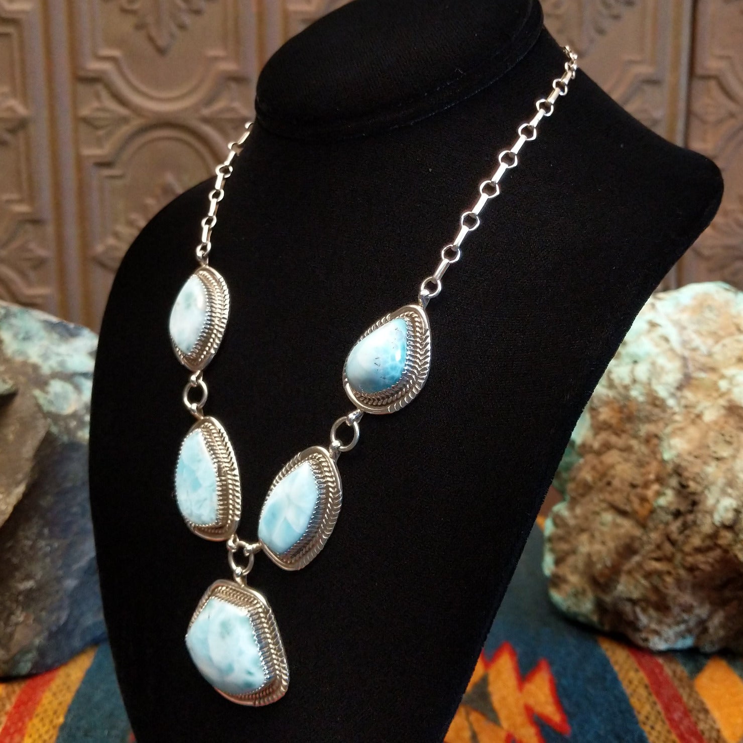 Sterling silver necklace with larimar set in geometric bezels, framed by twisted rope and stamped accents.