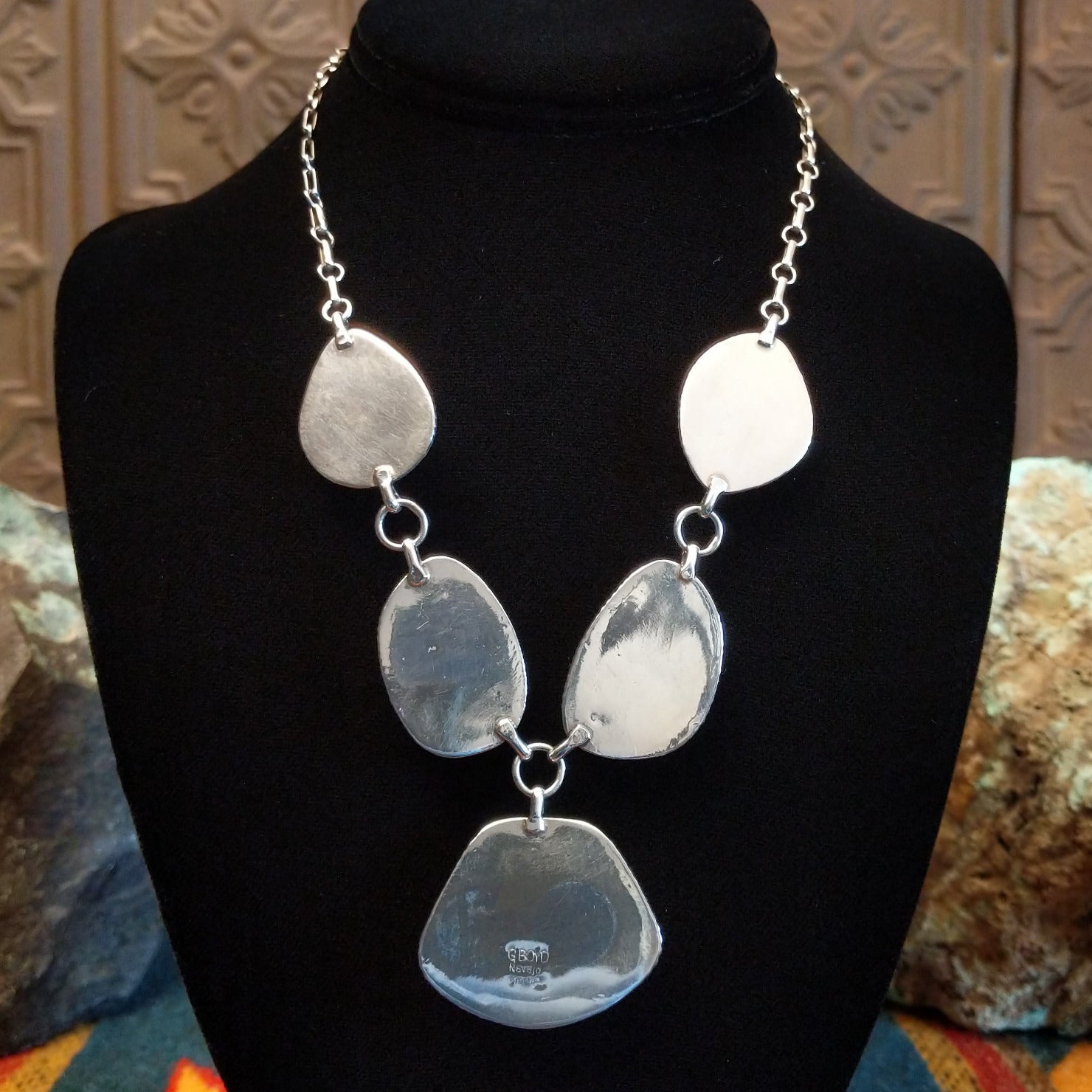Sterling silver necklace with larimar set in geometric bezels, framed by twisted rope and stamped accents.