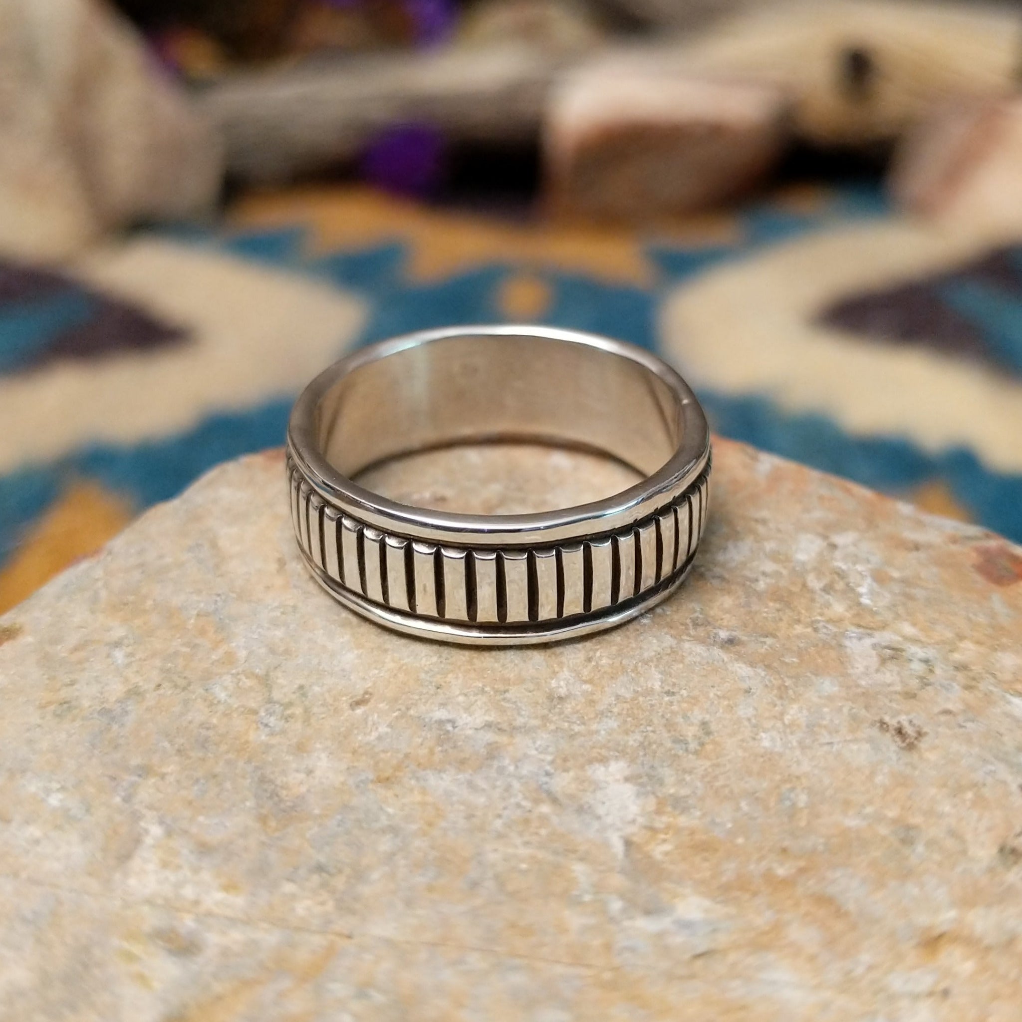 Sterling silver band ring by Bruce Morgan with hand-stamped linear detailing.