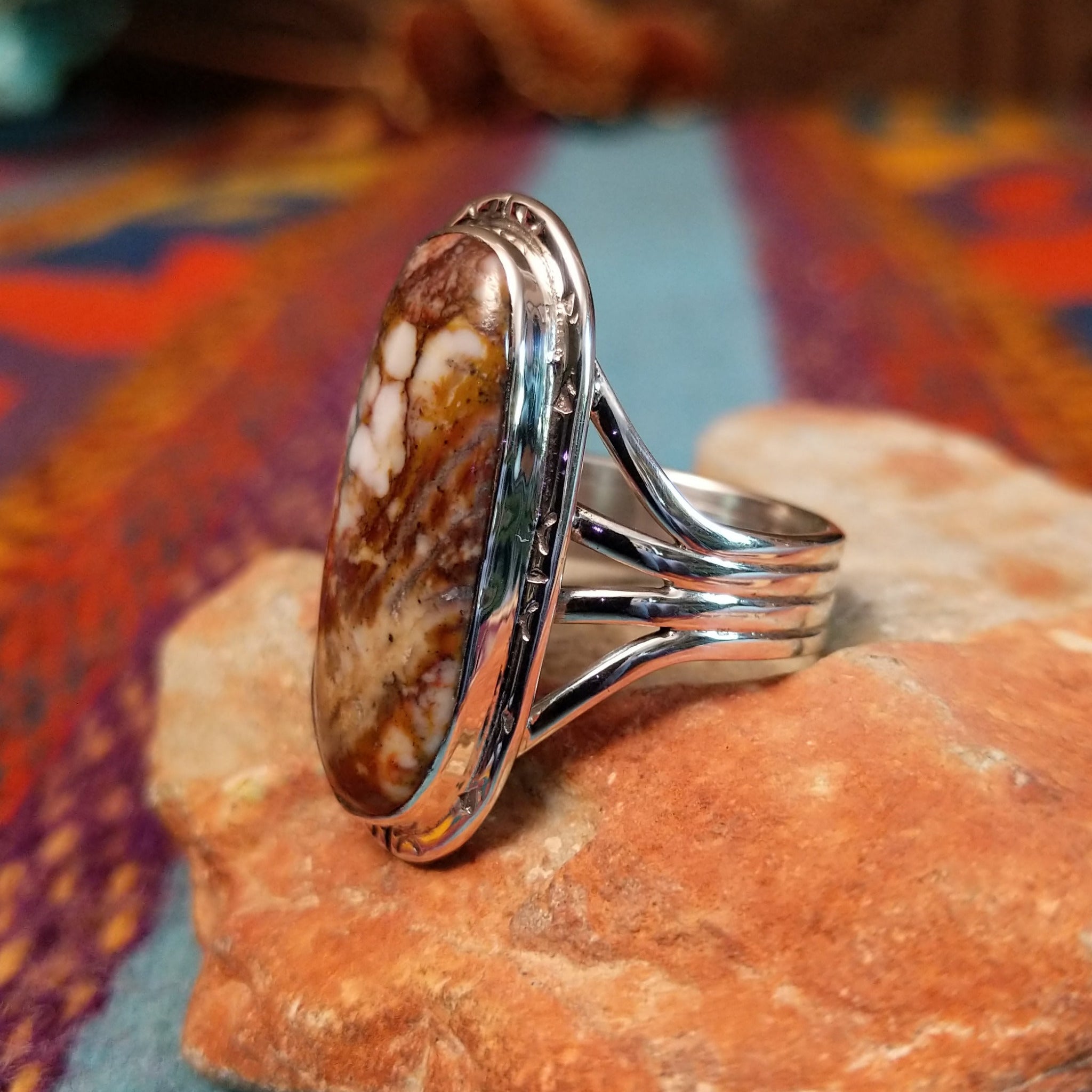 Long Oval Wild Horse Ring by John King featuring a large Wild Horse stone with brown, rust, cream, and white matrix set in Sterling Silver with detailed silverwork and a split-shank band; side view.