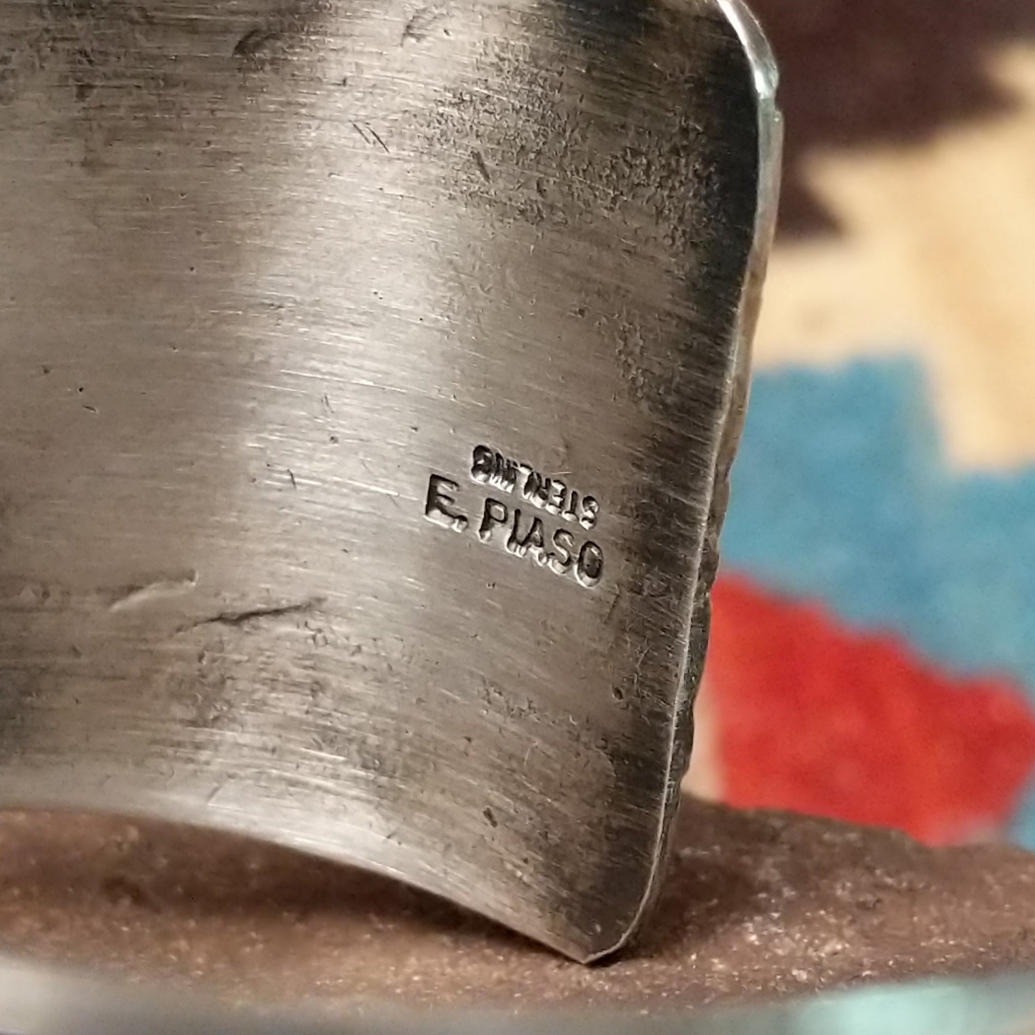 Longhorn stamped sterling silver cuff by E. Piaso, featuring bold geometric hand-stamped longhorn-inspired patterns on a handcrafted wide sterling silver open cuff. Artisan and Sterling Silver stamp.