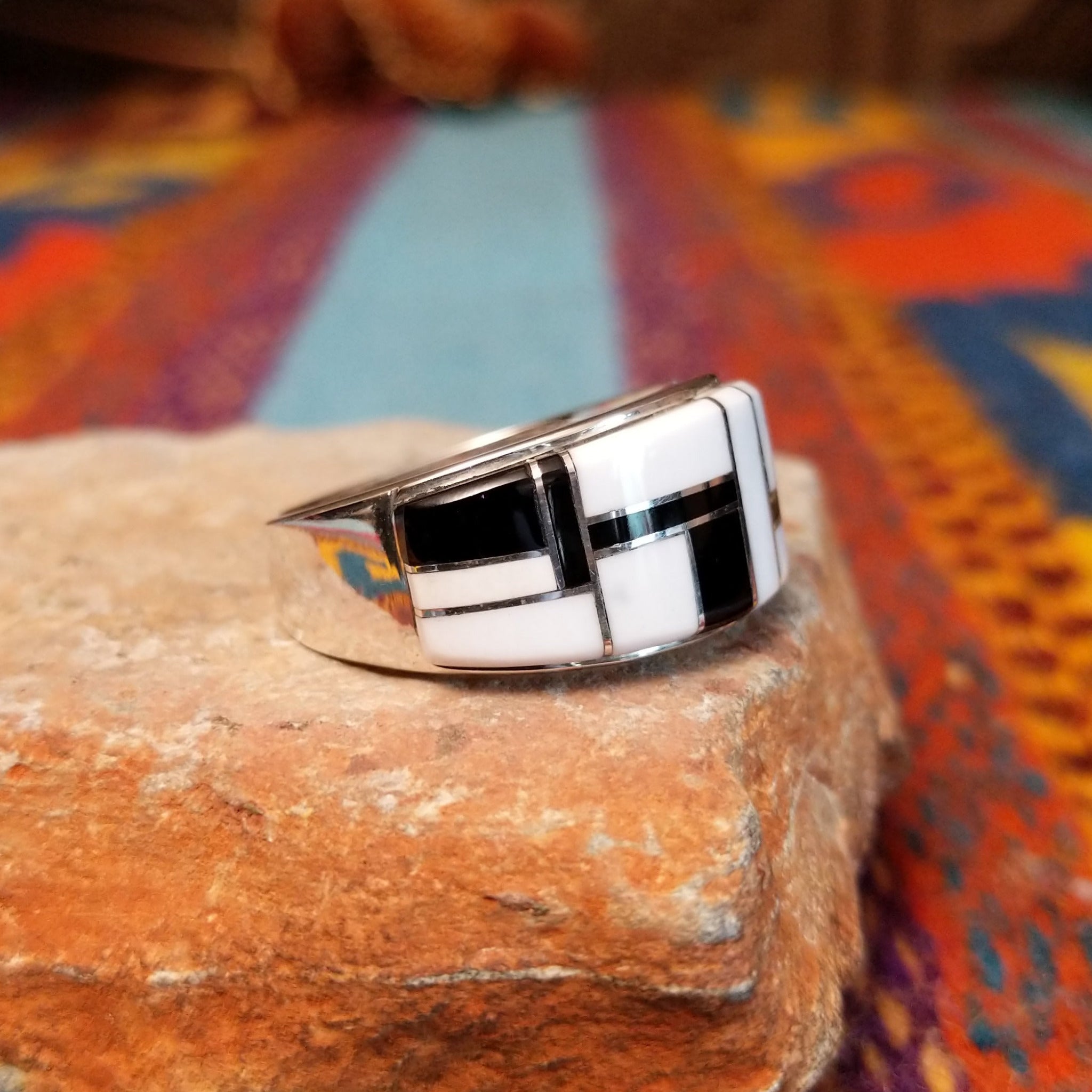 Magnesite & Black Onyx Ring by Karen Skeet featuring geometric white magnesite and black onyx inlay separated by fine silver channels across a wide polished silver band; side view.