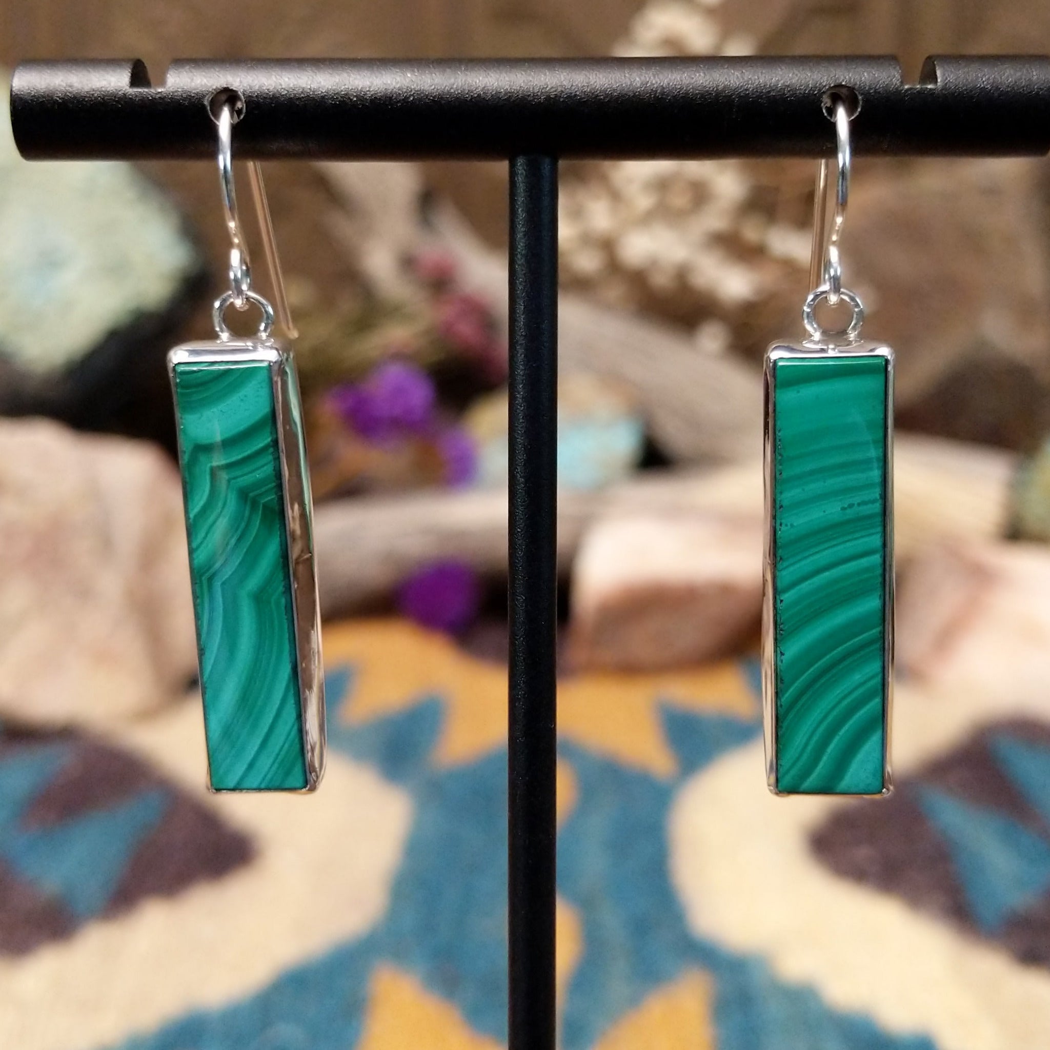 Handcrafted sterling silver pillar earrings by Juan Willie featuring rectangular natural malachite with vibrant green banding and French hook ear wires.