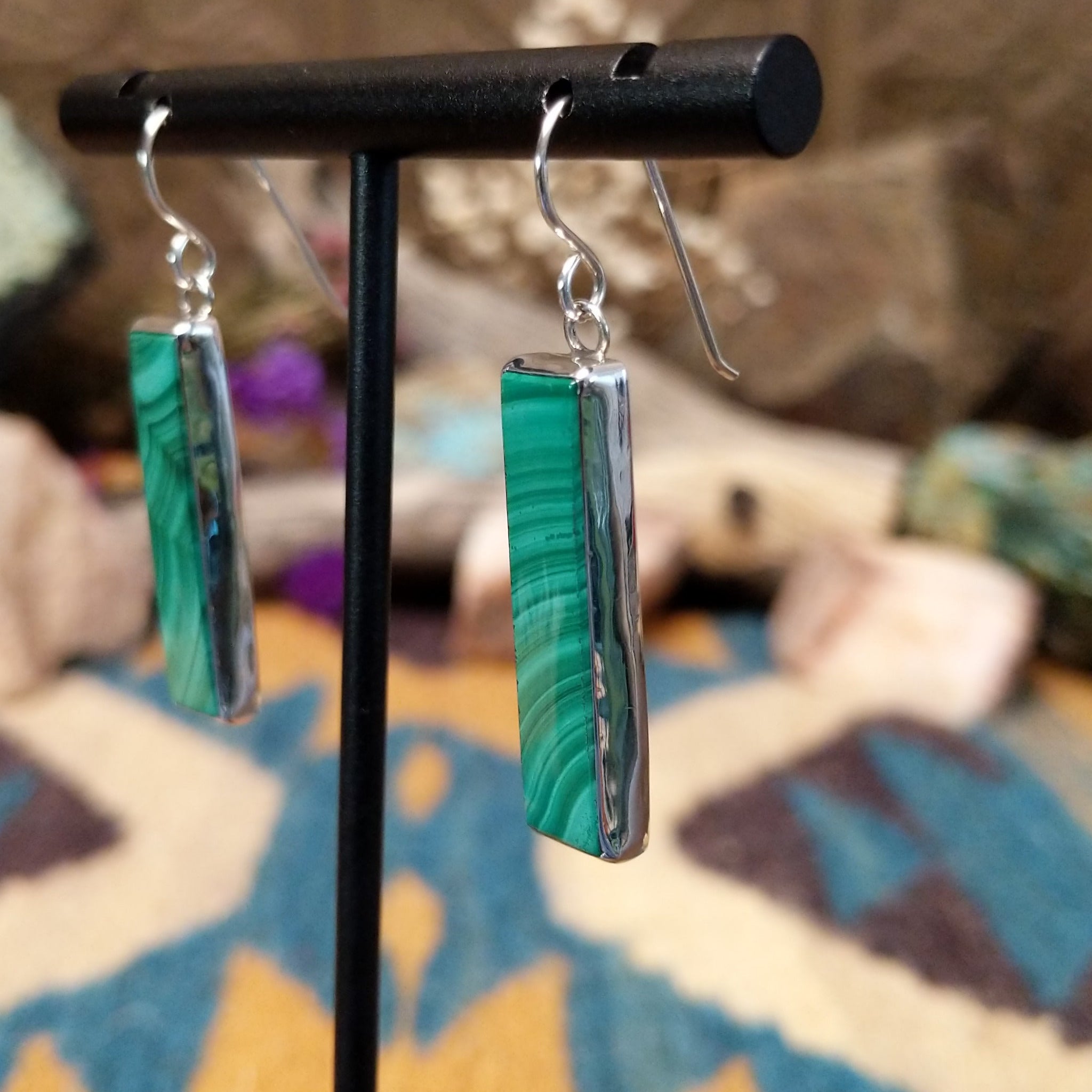 Handcrafted sterling silver pillar earrings by Juan Willie featuring rectangular natural malachite with vibrant green banding and French hook ear wires; side view.