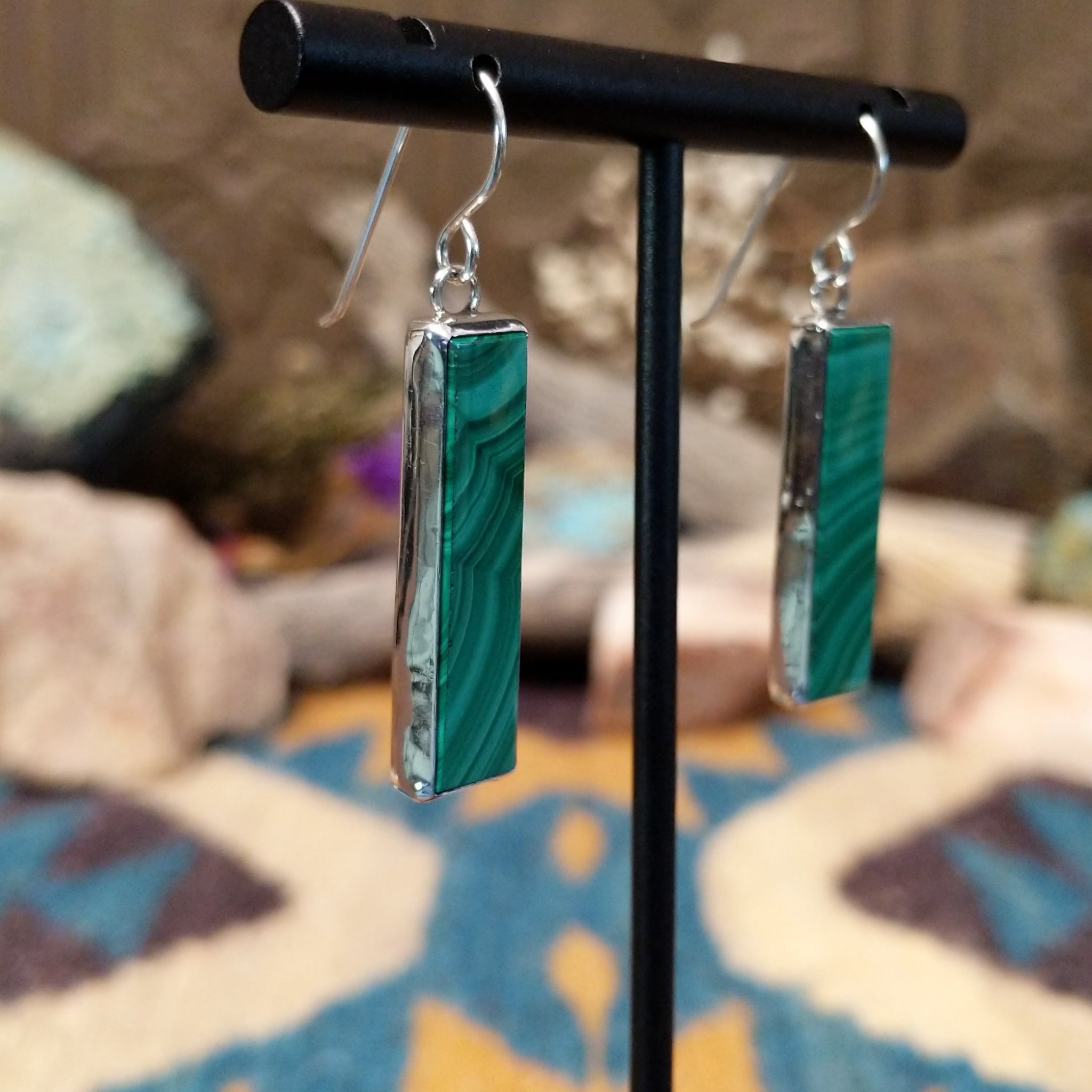 Handcrafted sterling silver pillar earrings by Juan Willie featuring rectangular natural malachite with vibrant green banding and French hook ear wires; side view.